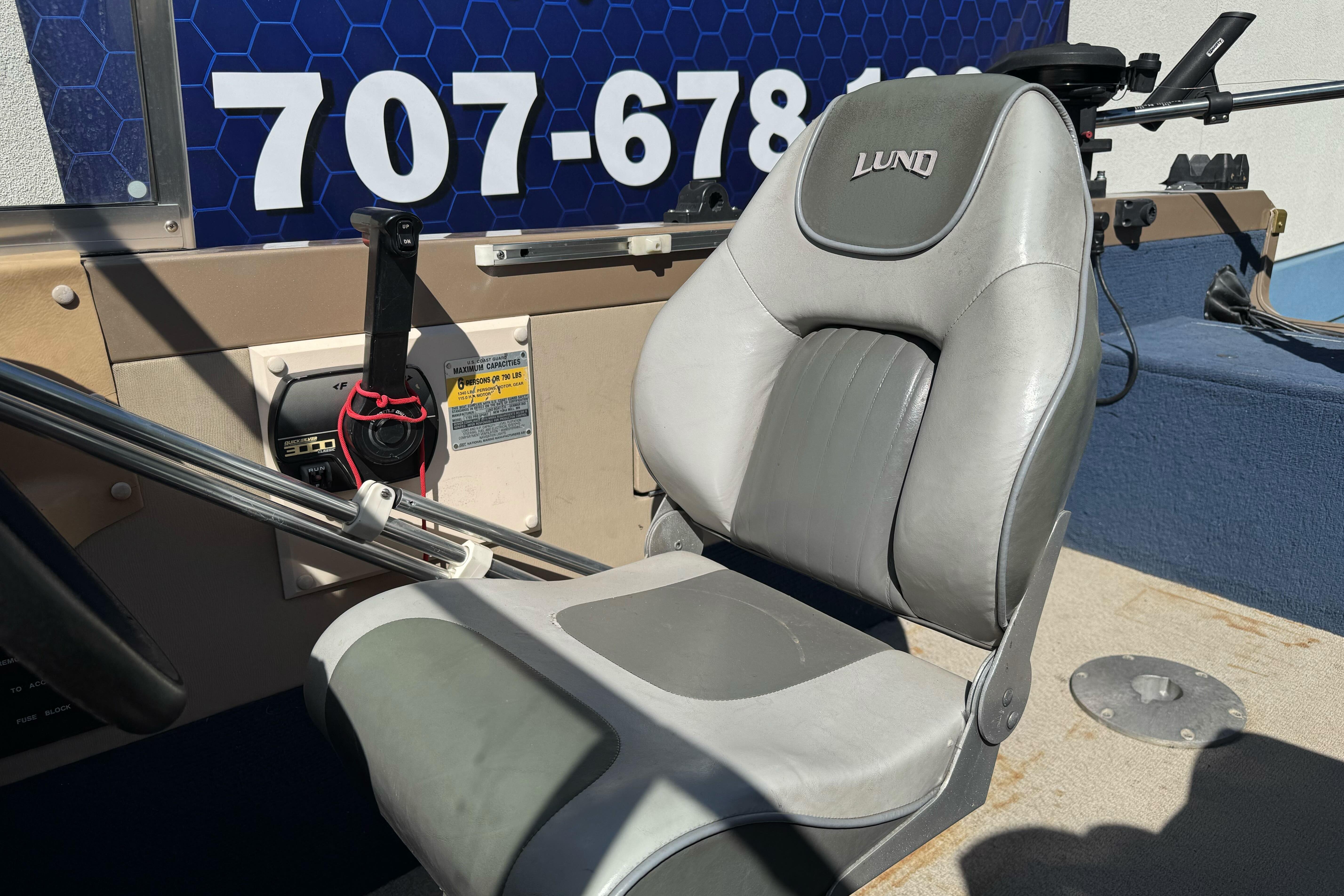 1998 Lund 1700 Pro Sport boat seat and control panel with visible contact number.