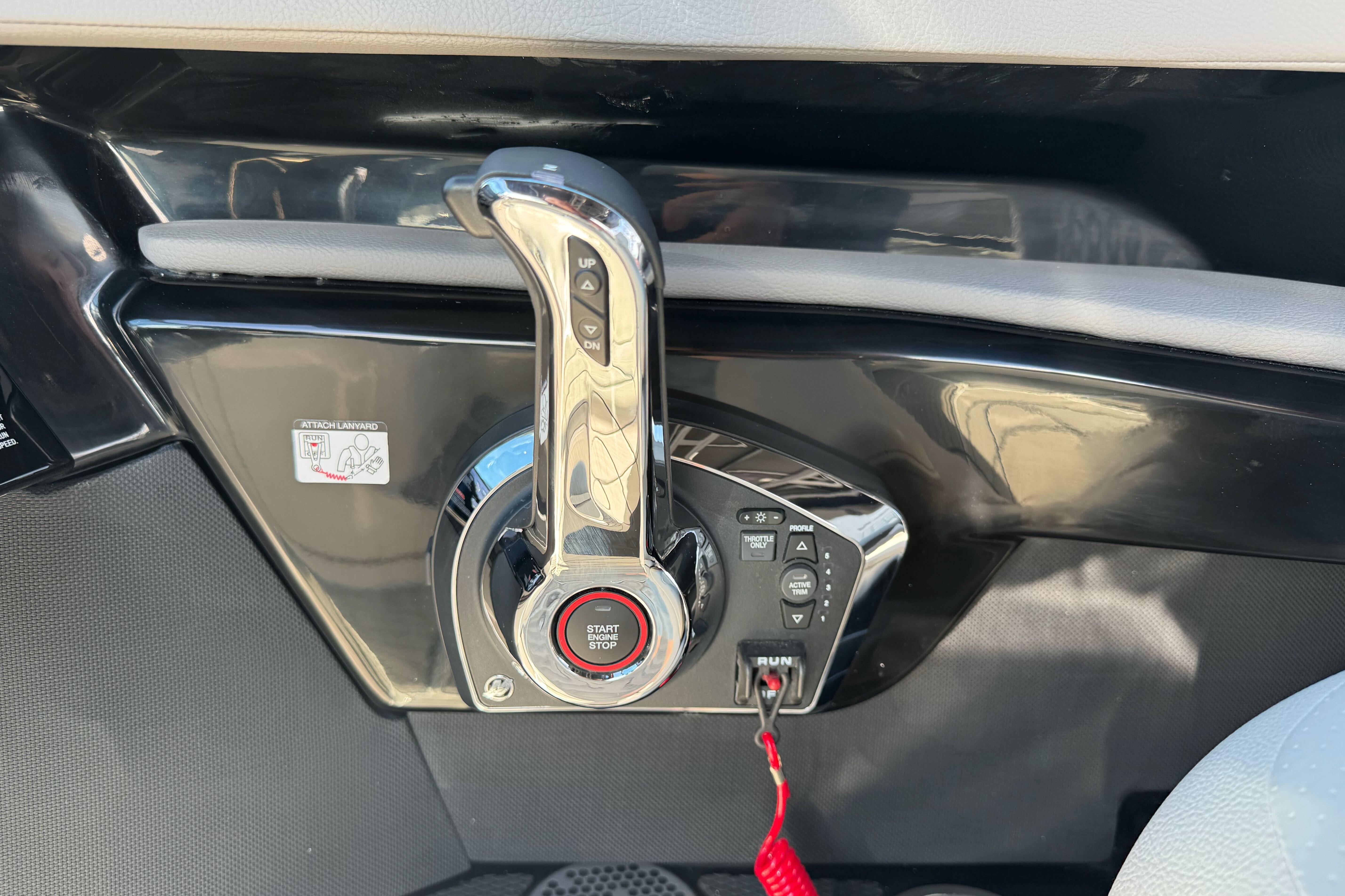 Control panel of 2026 Sea Ray SLX 260 boat with start-stop button and throttle lever.