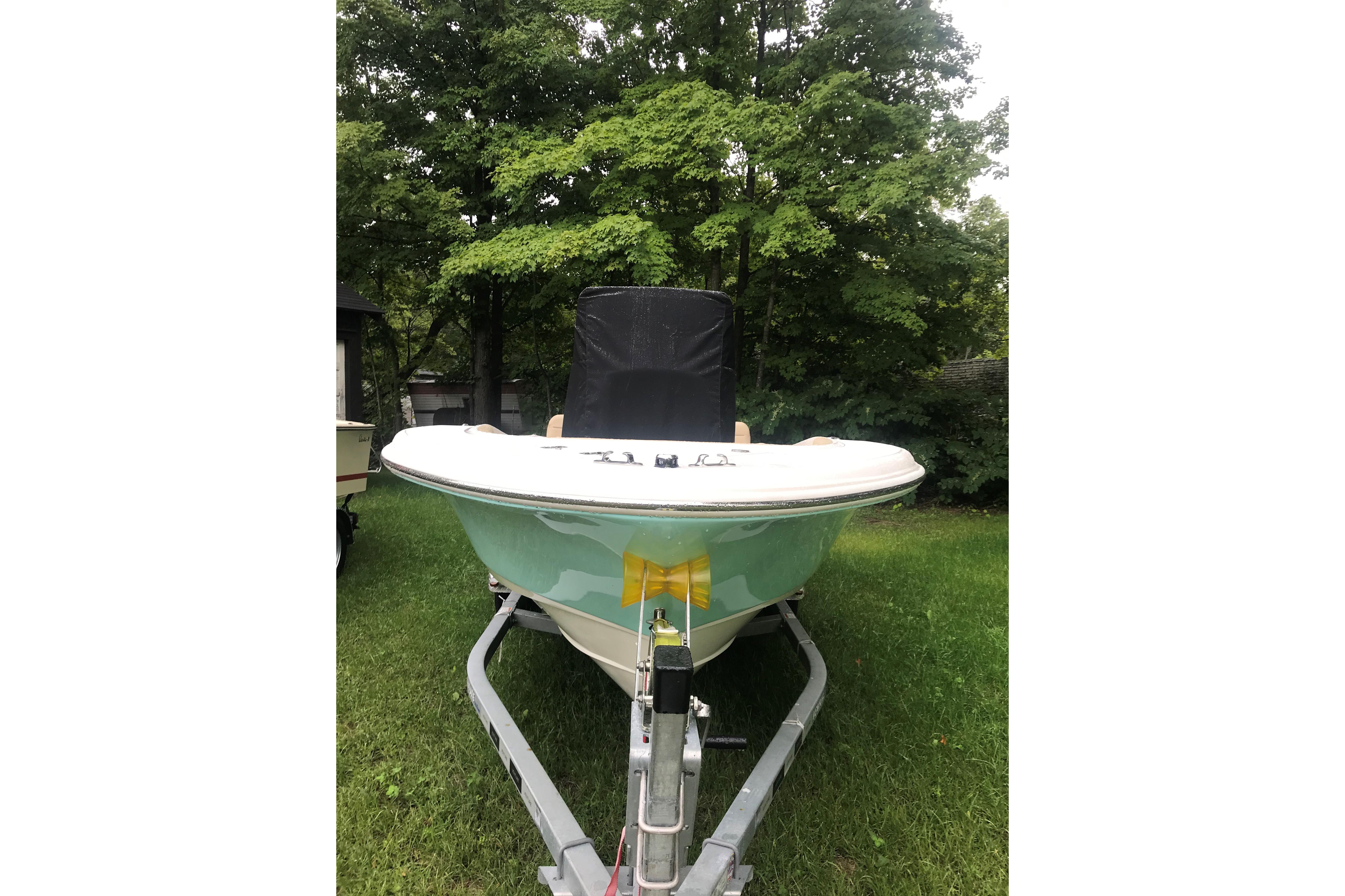 2026 Pioneer 180 Islander boat on trailer, parked on grass with trees in background.
