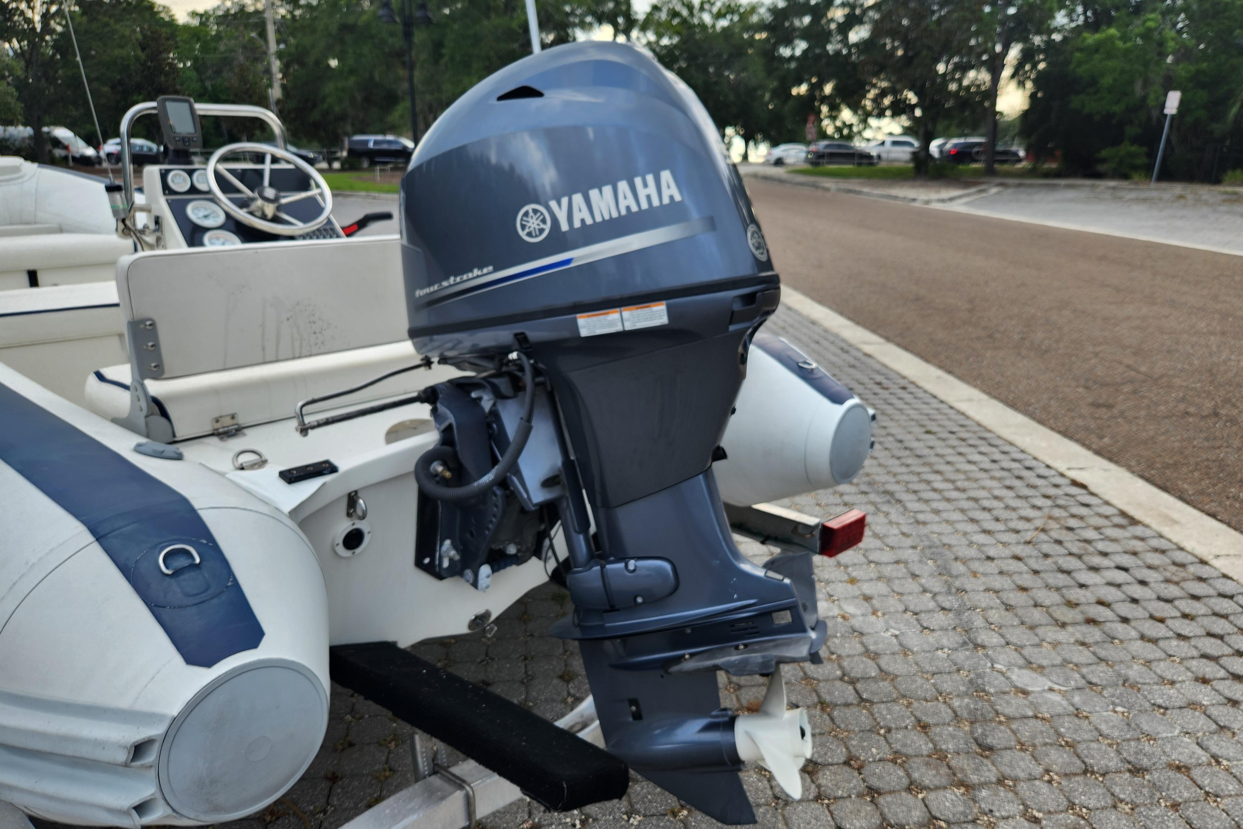 2019 Novurania DL 400 boat with Yamaha outboard motor, parked on cobblestone pavement.