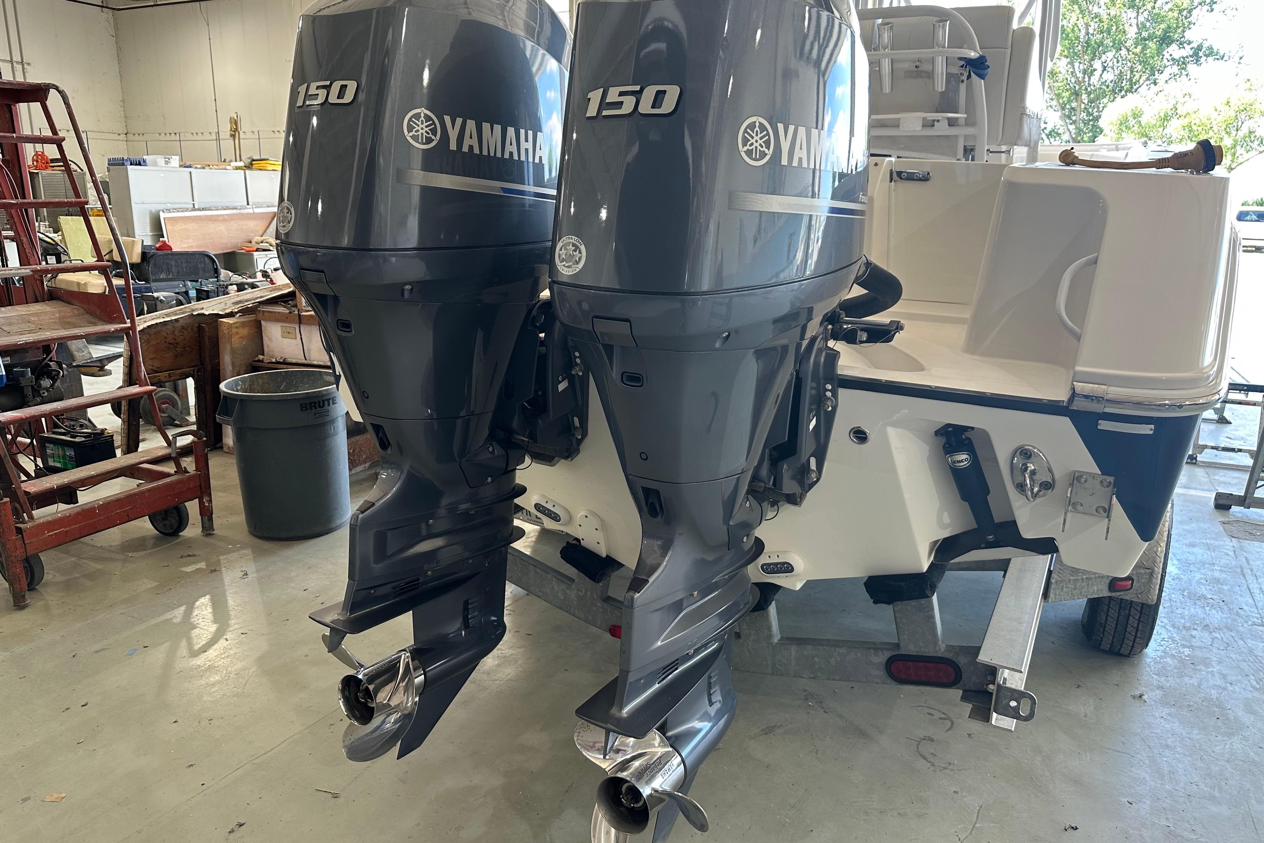 2015 Edgewater 245CC boat with dual Yamaha 150 outboard motors in a workshop setting.