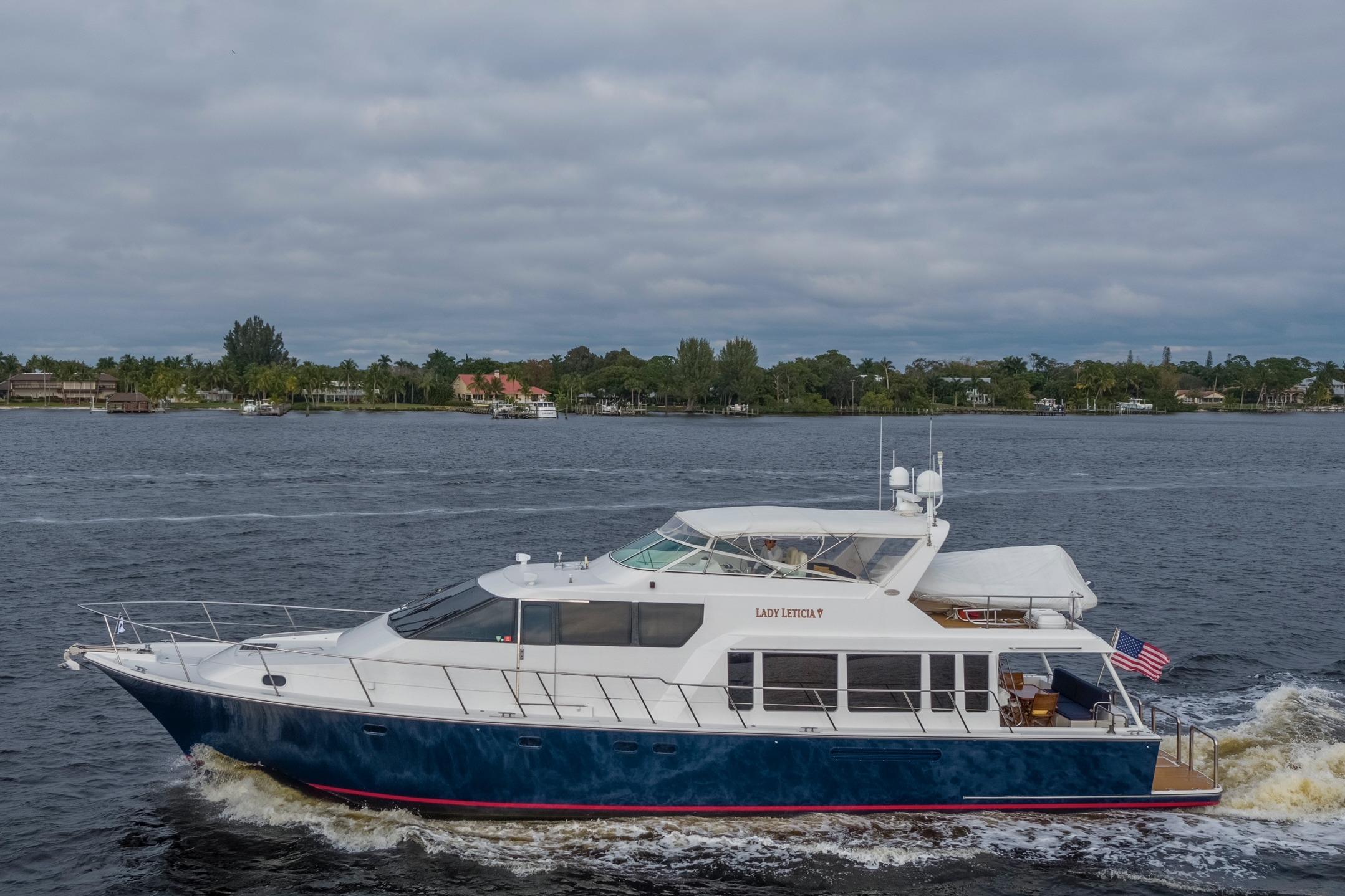 2000 Pacific Mariner 65 Motoryacht cruising on a calm waterway under cloudy skies.