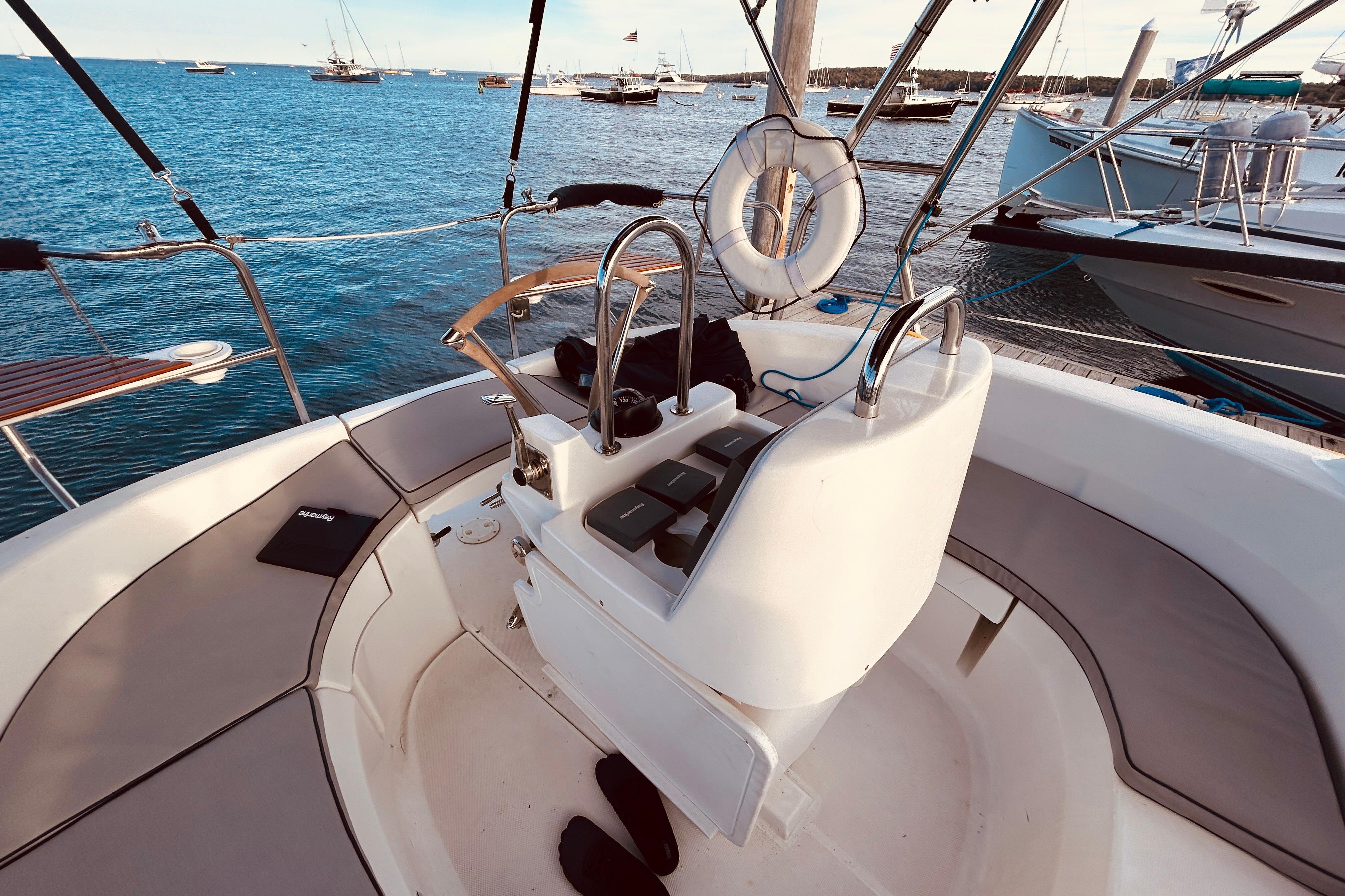 Cockpit of 2003 Hunter 386 sailboat with ocean view and moored vessels.