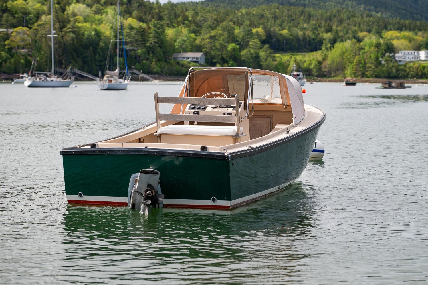 1989 Ellis 24 Open boat on calm water with scenic forested background.
