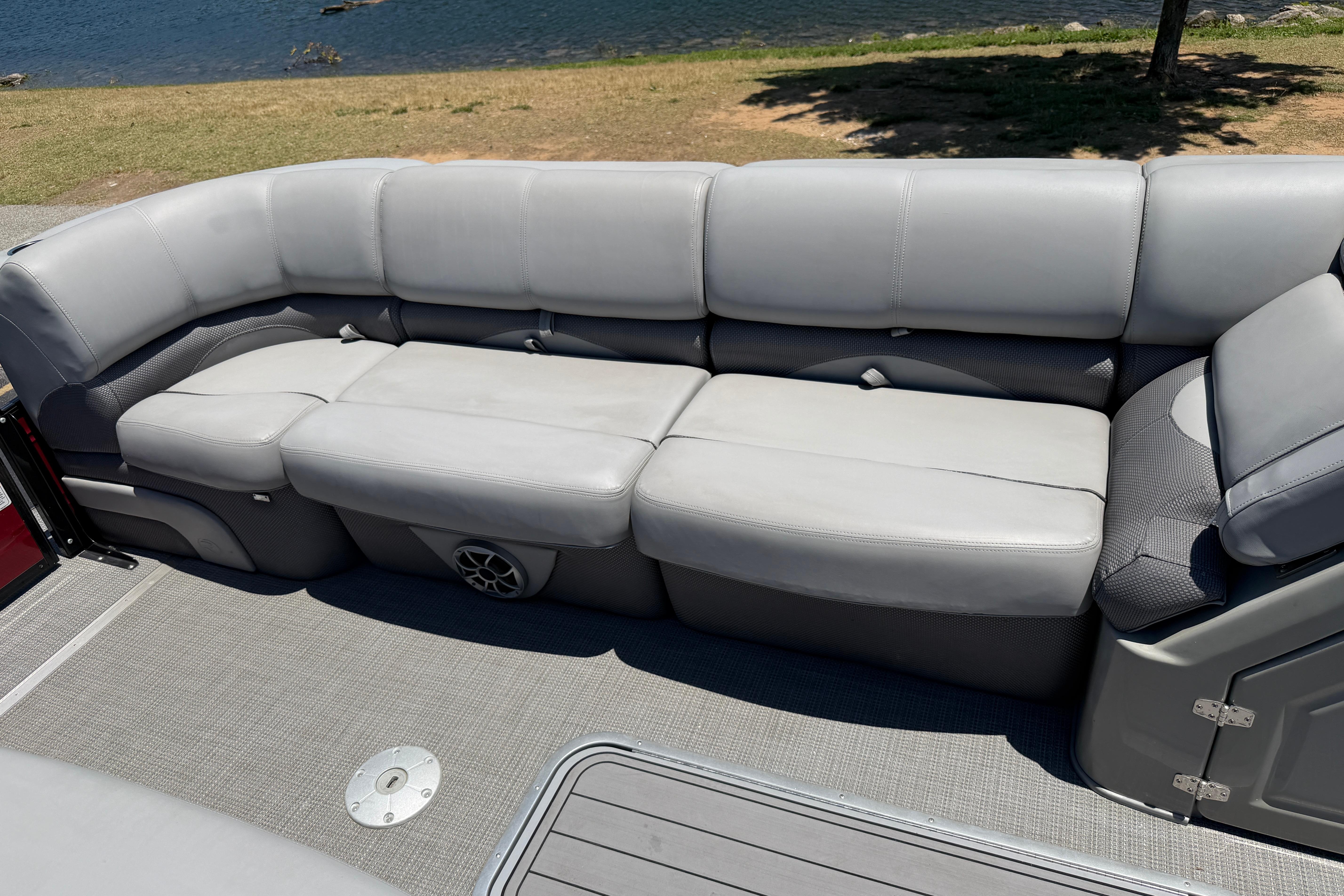 Luxurious seating on 2024 Regency R250DL3 pontoon boat by the water.
