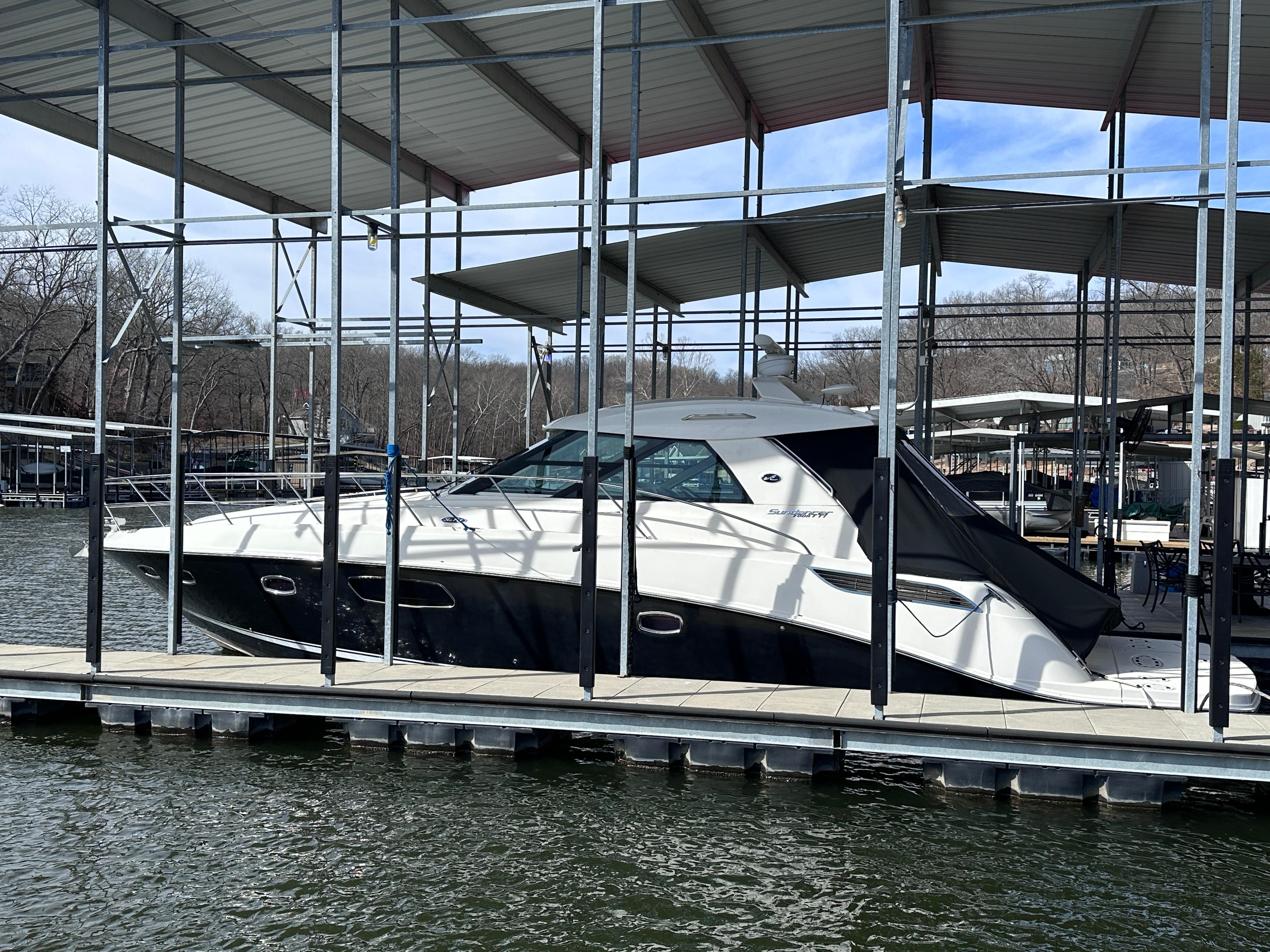 2012 Sea Ray 450 Sundancer yacht docked under a covered marina.