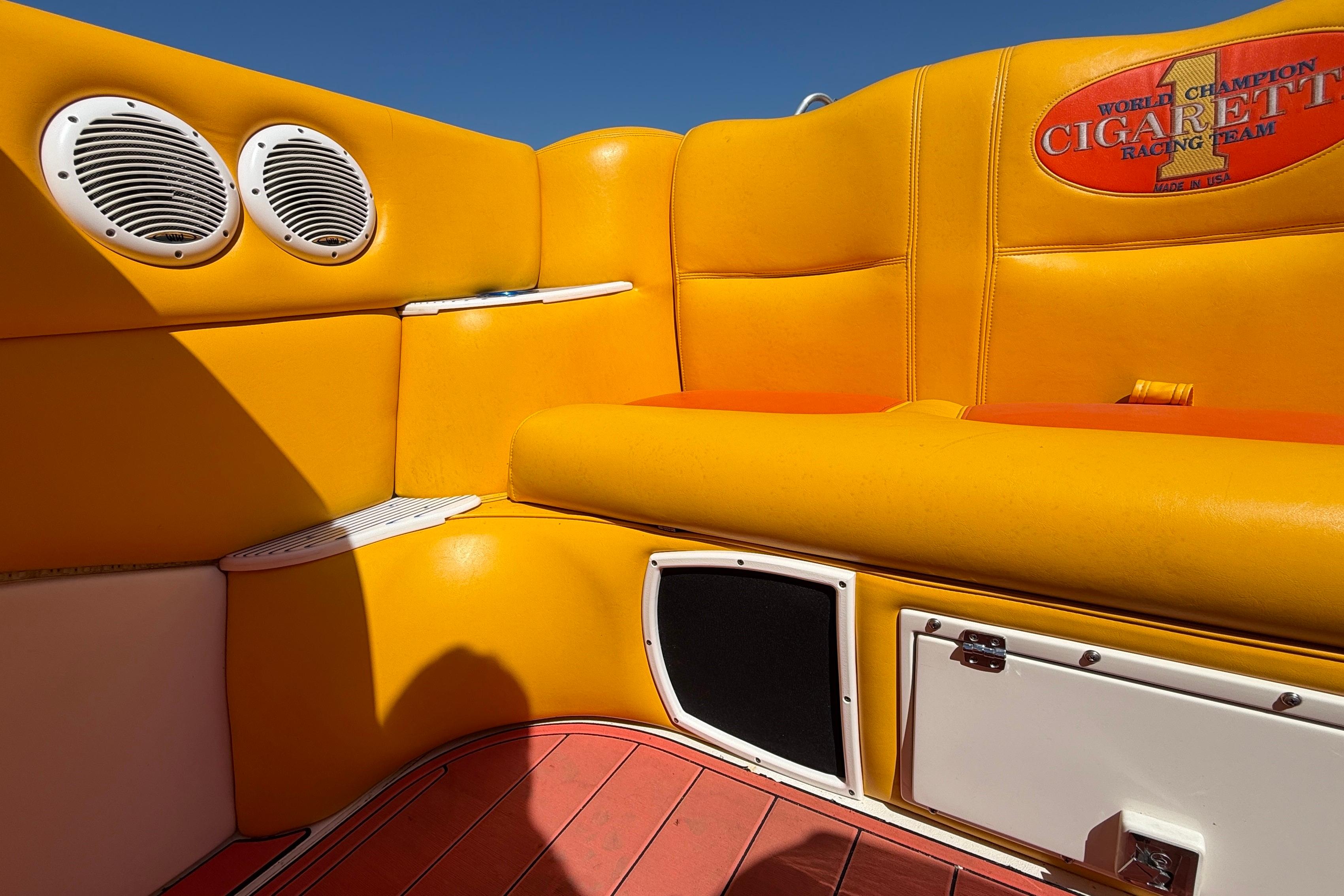 Interior of a 2002 Cigarette 35' Cafe Racer boat with vibrant yellow seating.