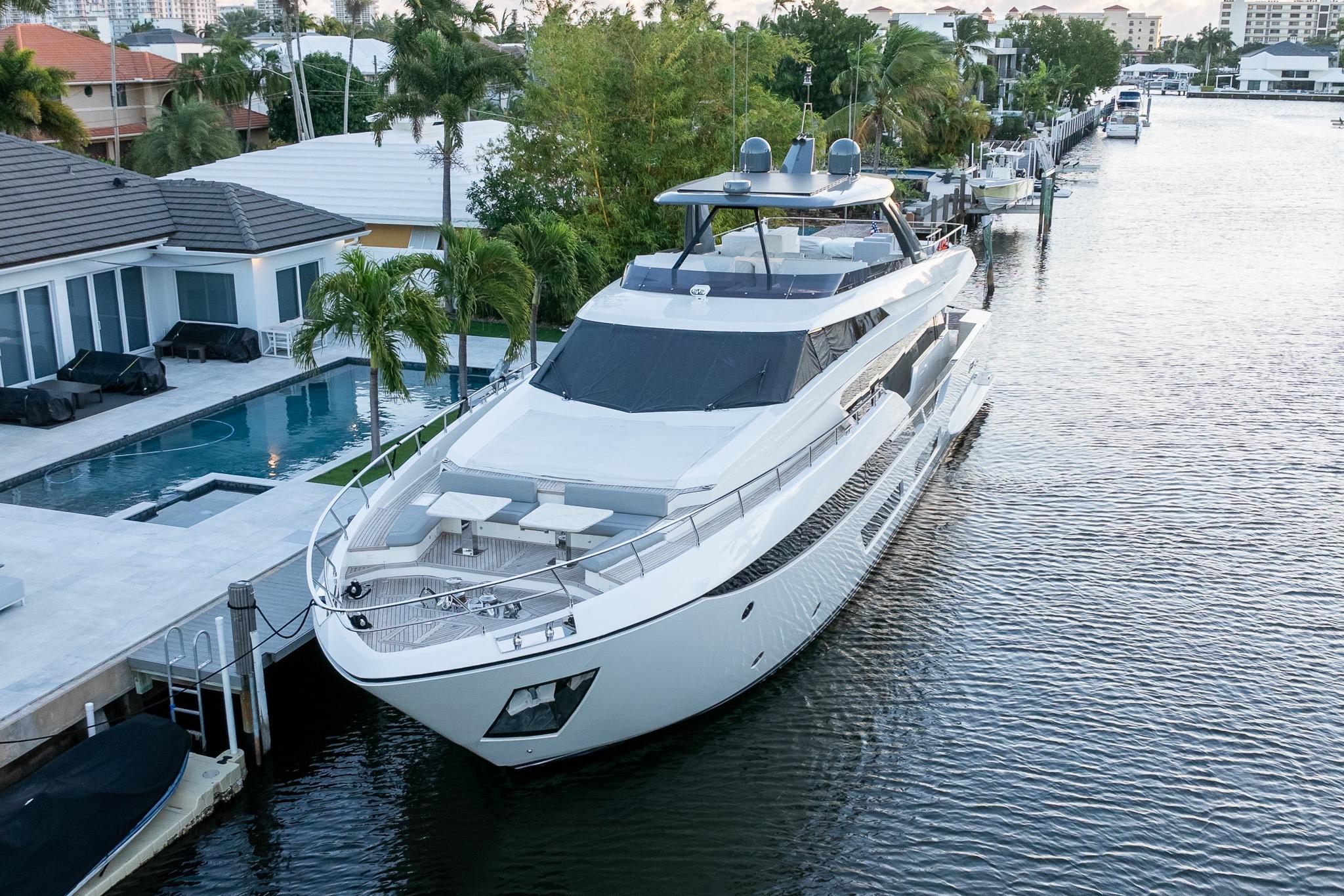 Luxurious 2021 Ferretti Yachts 920 docked by a modern waterfront home.