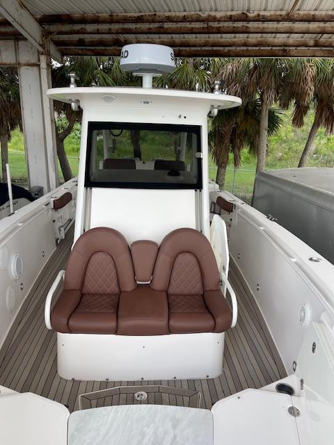 2014 Everglades 325 Center Console boat with brown seating under a canopy.
