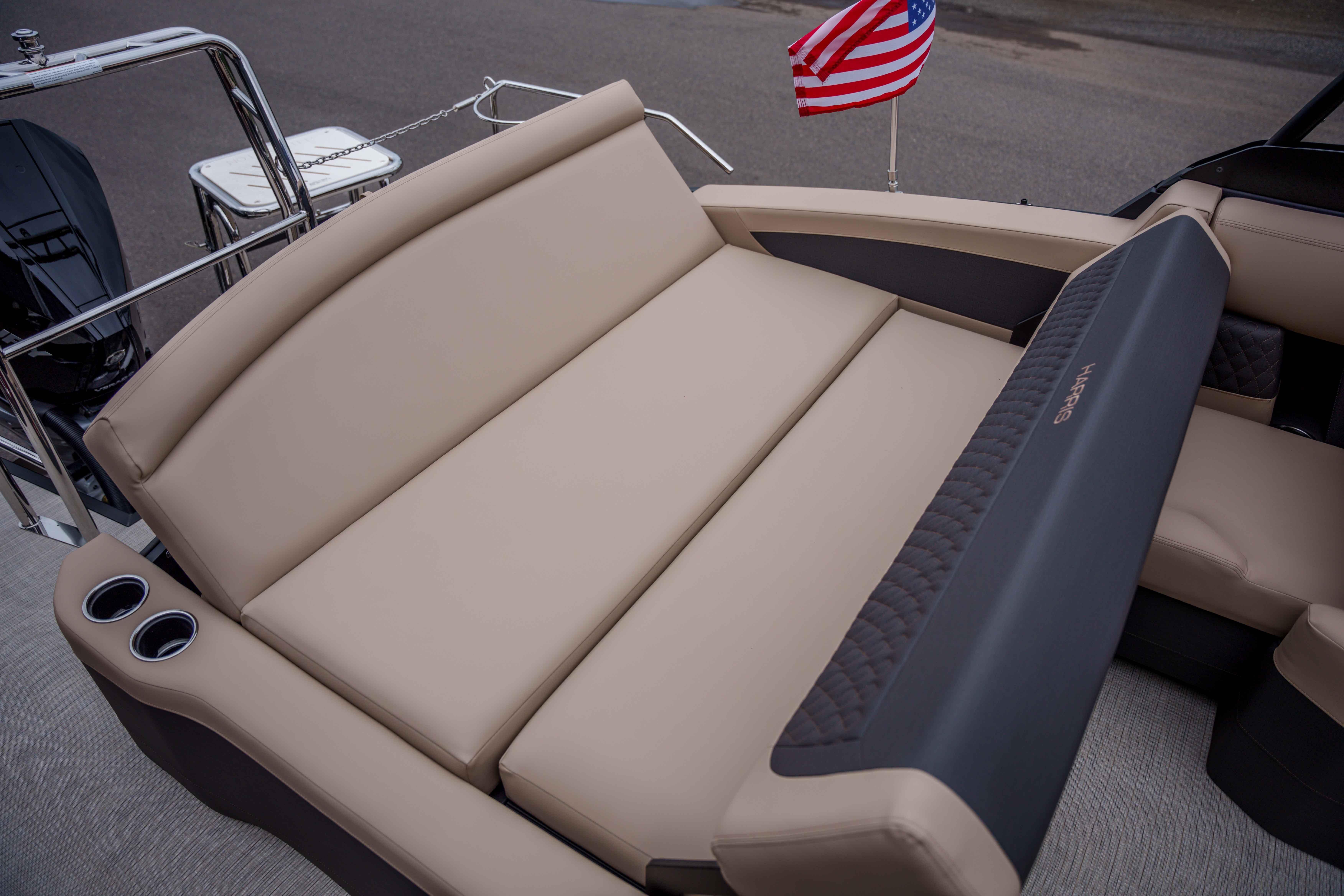 Luxurious seating on 2026 Harris Sunliner 230 pontoon boat with American flag.