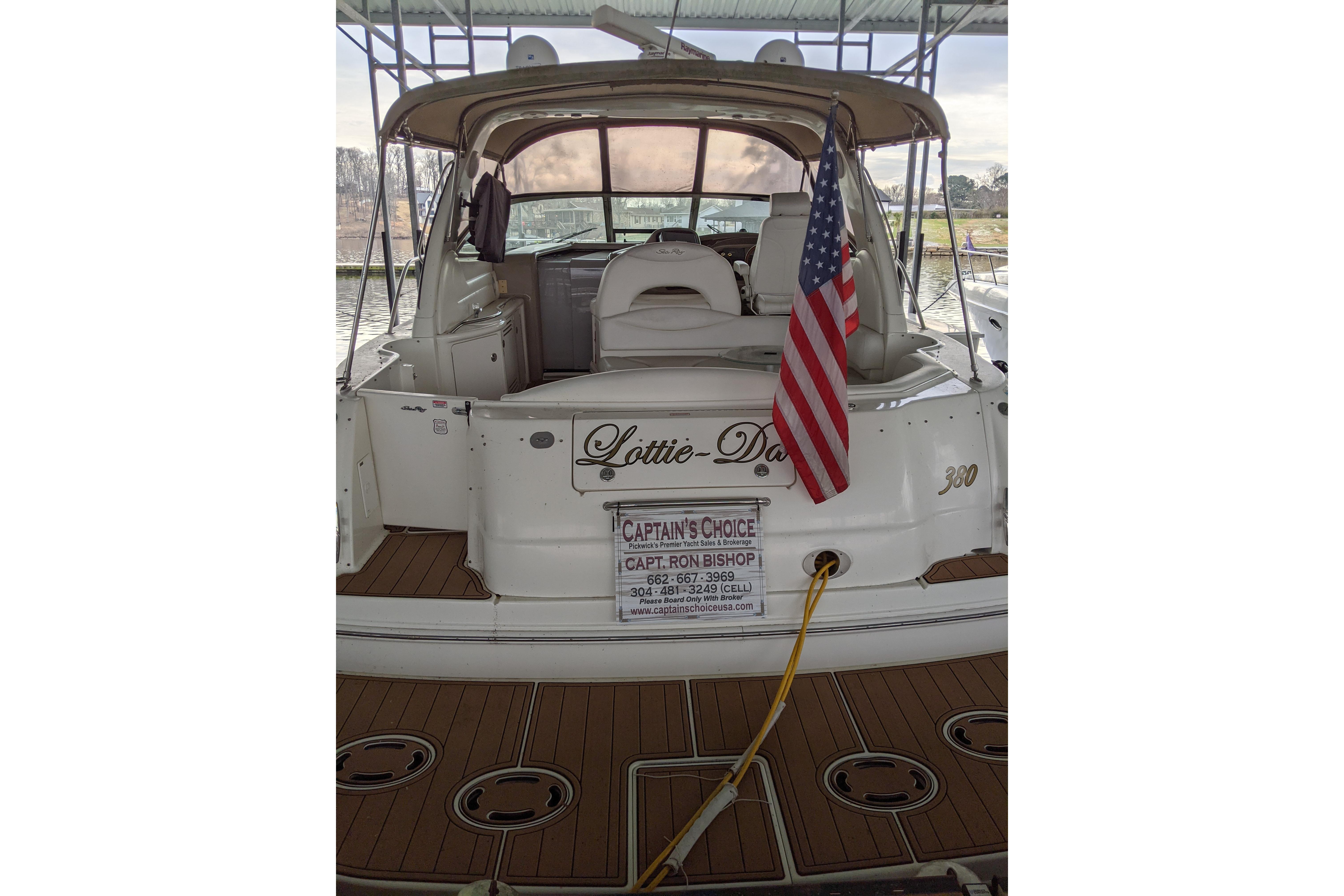 2004 Sea Ray 380 Sundancer docked, displaying American flag and "Lottie-Da" name.