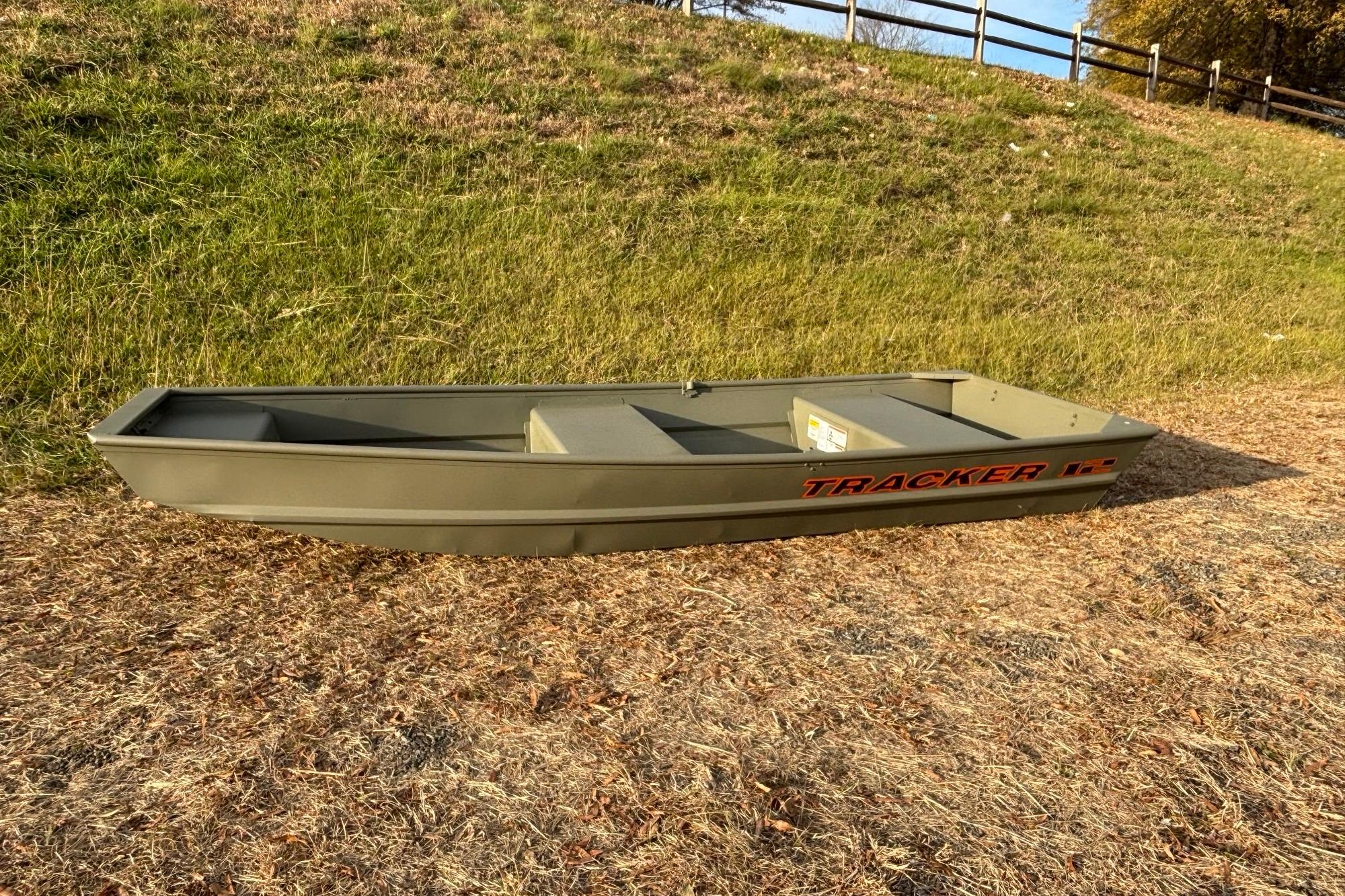 2026 Tracker Grizzly 12 Jon boat on grassy terrain, side view.