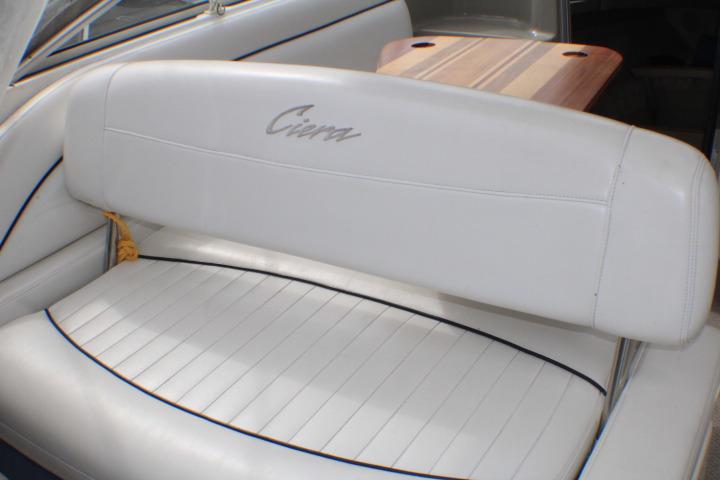 1998 Bayliner 2655 Ciera Sunbridge interior with white seating and wooden table.