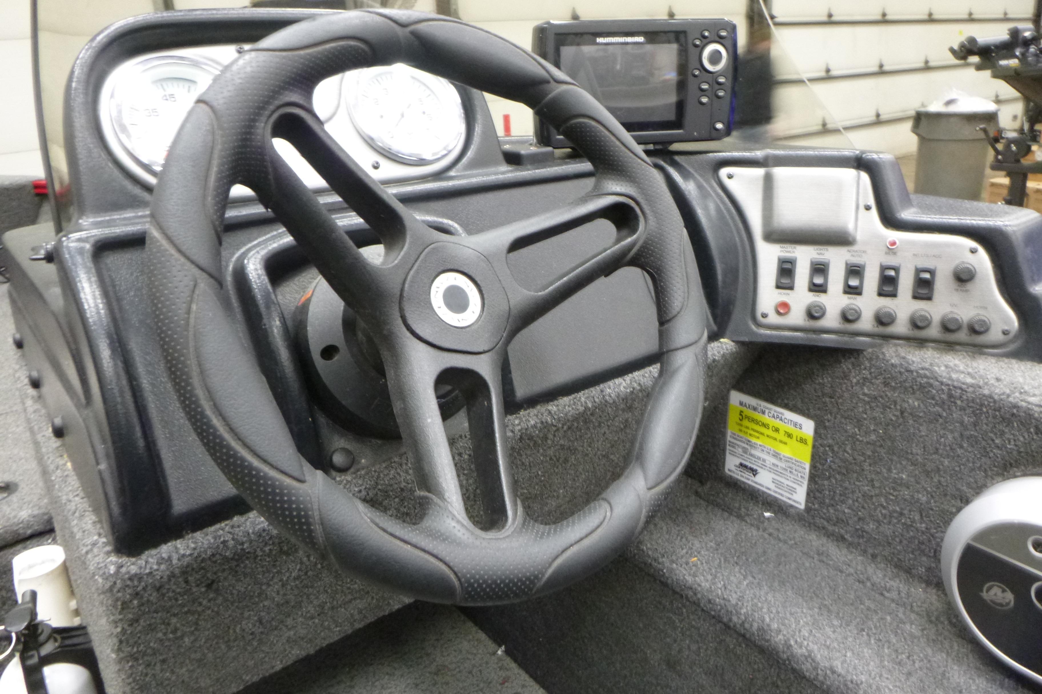 Steering console of 2022 Lund 1650 Angler Sport boat with gauges and controls.