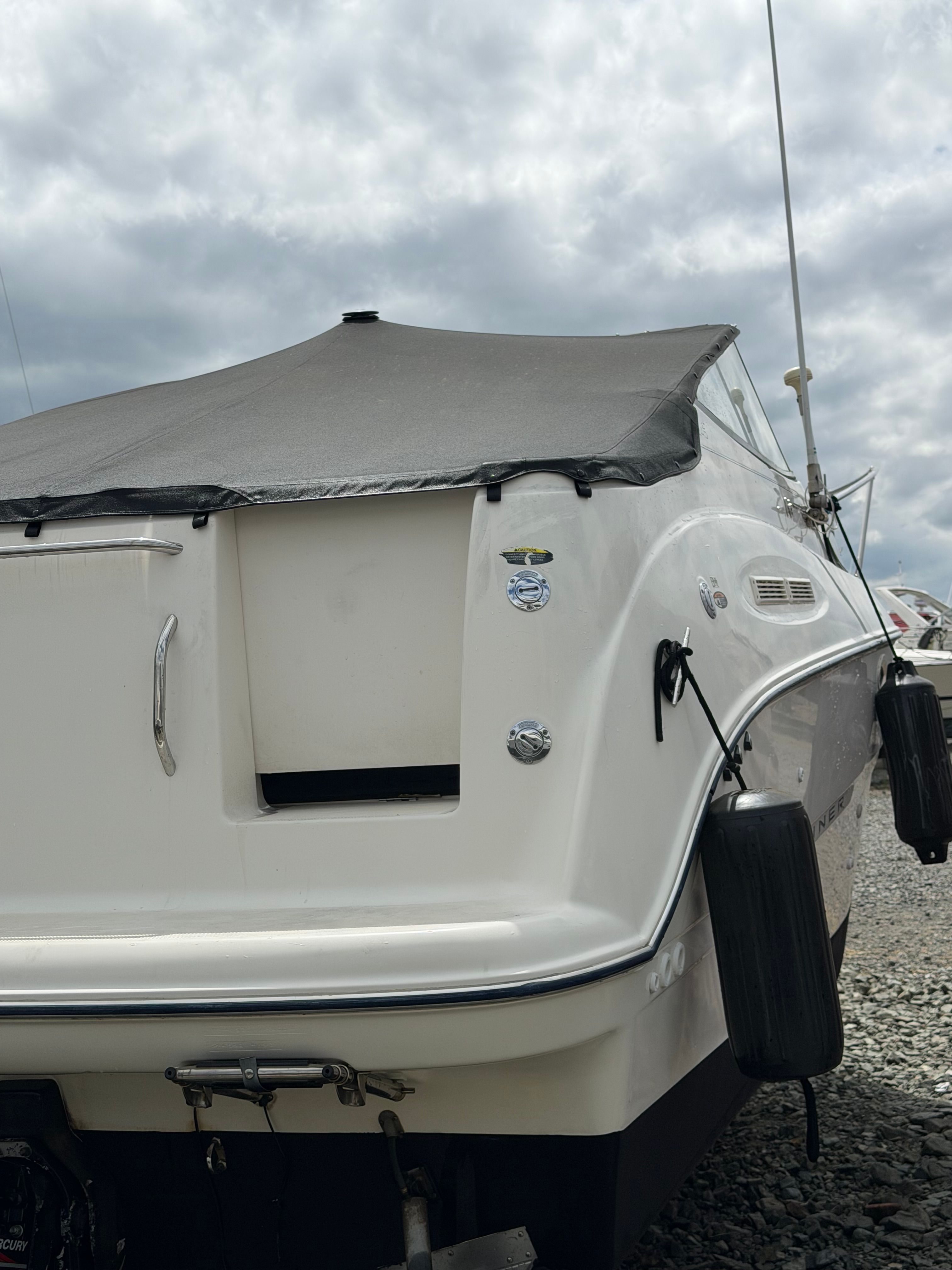 2005 Bayliner Cierra 245 boat with cover, cloudy sky.