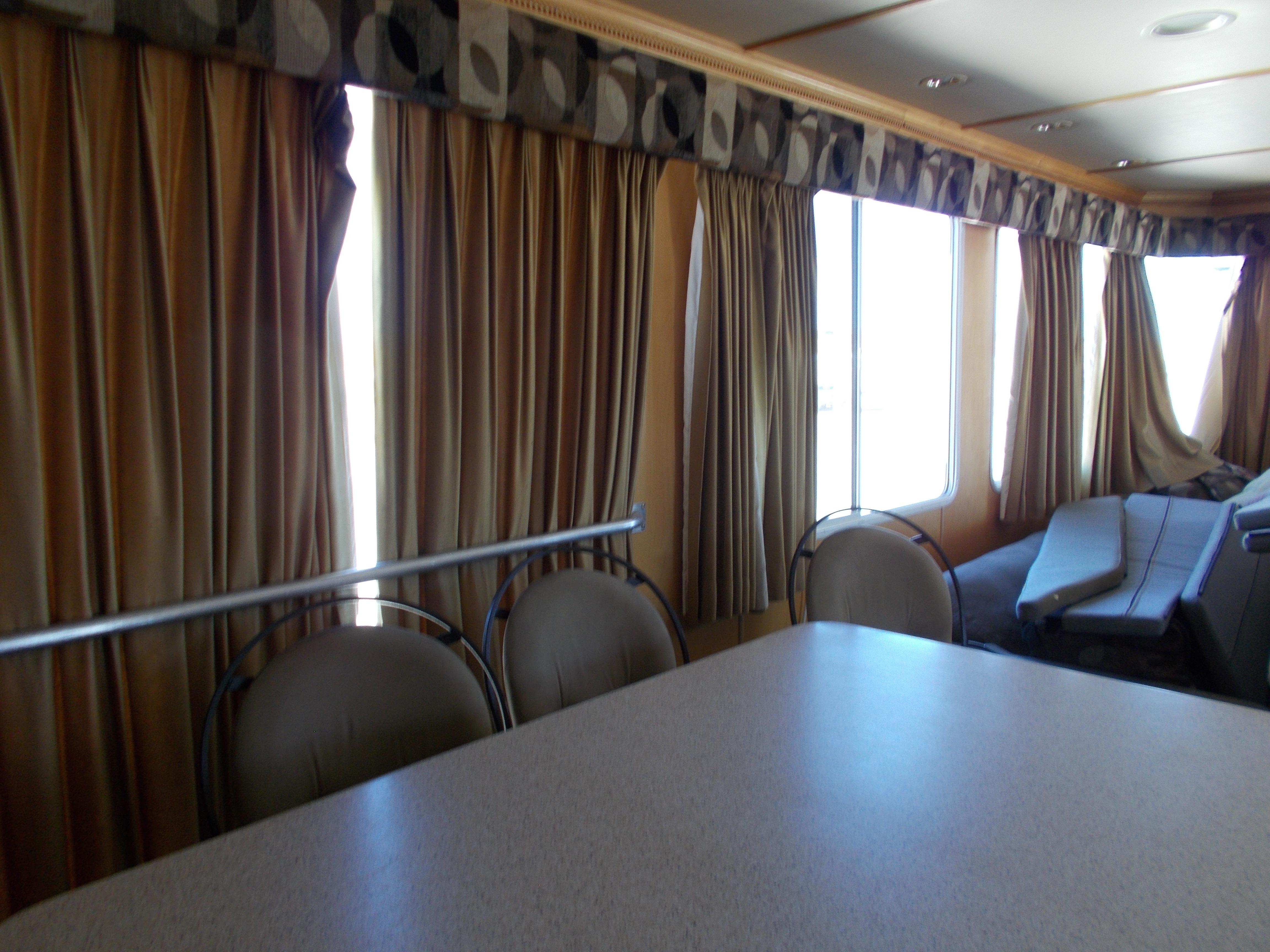 Interior of 2005 Stardust Cruisers Summer Obsession Trip 36 houseboat with curtains and seating area.