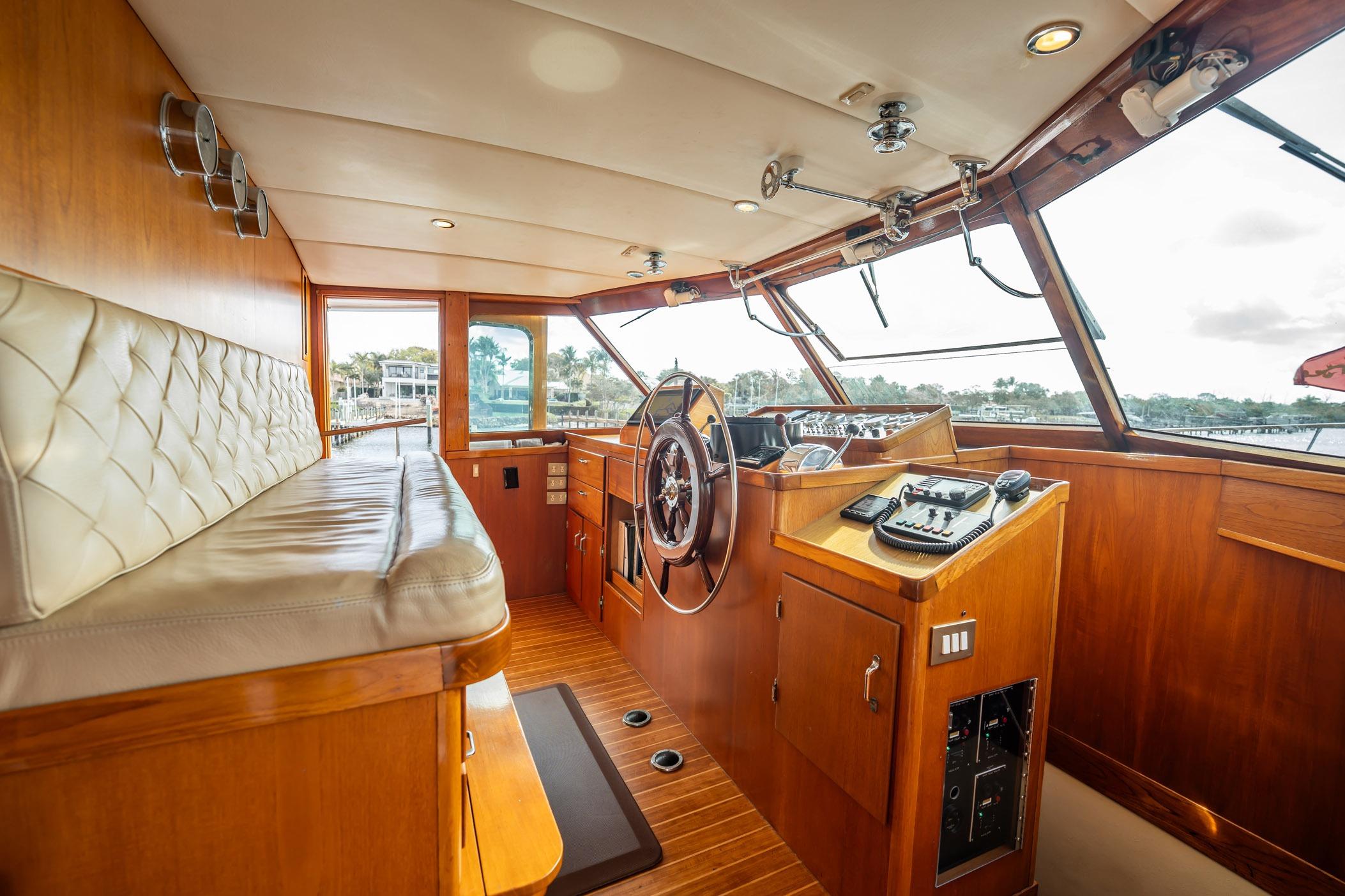 Interior of 1972 Trumpy 72 Motor Yacht with wooden helm and seating area.