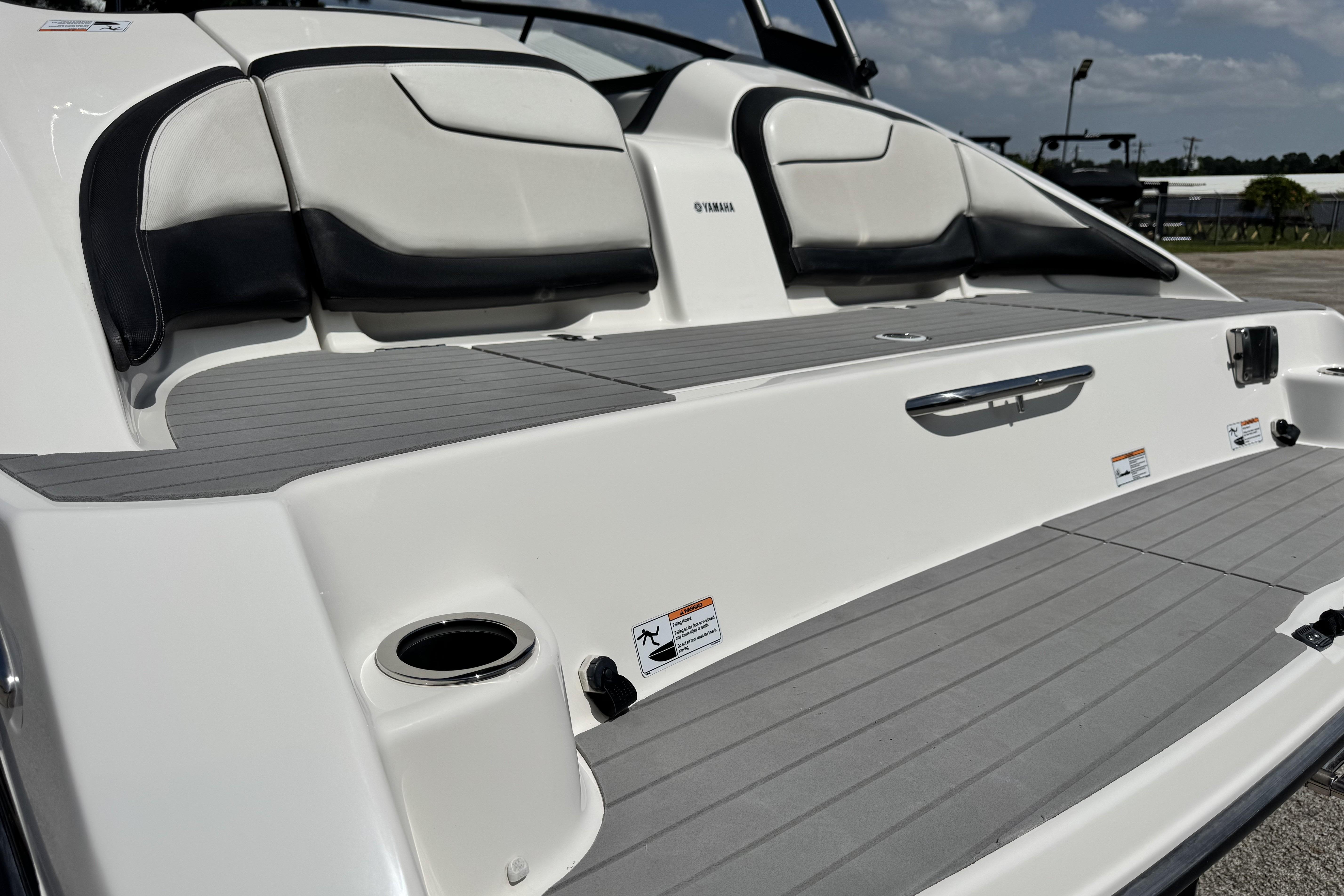 2018 Yamaha Boats AR210 swim platform with seating and cup holder, under clear sky.