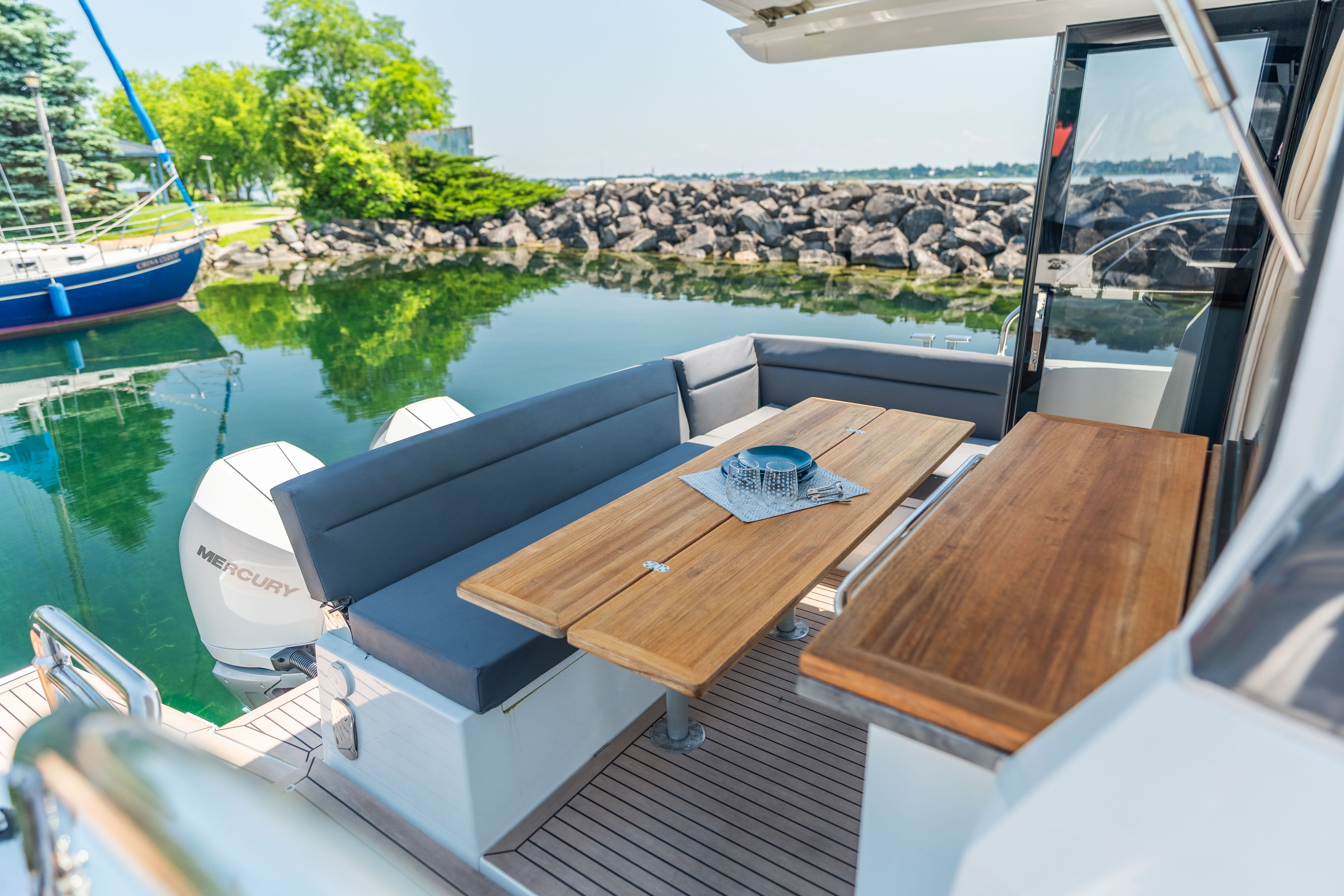 The image shows the stern of a 2023 Sealine C335V with a sleek seating area.