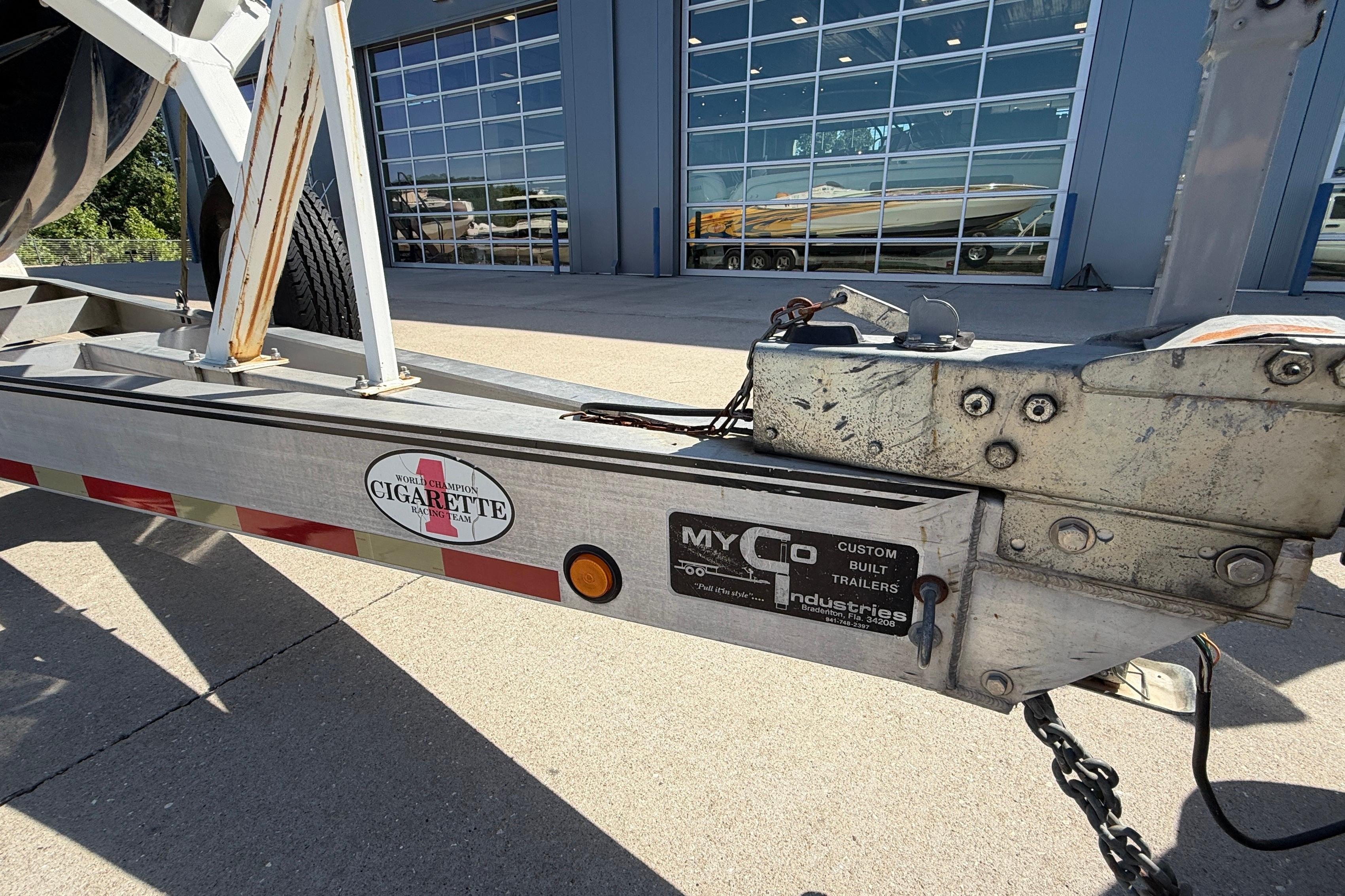 Trailer hitch of a 2002 Cigarette 35' Cafe Racer boat, parked outside a building.