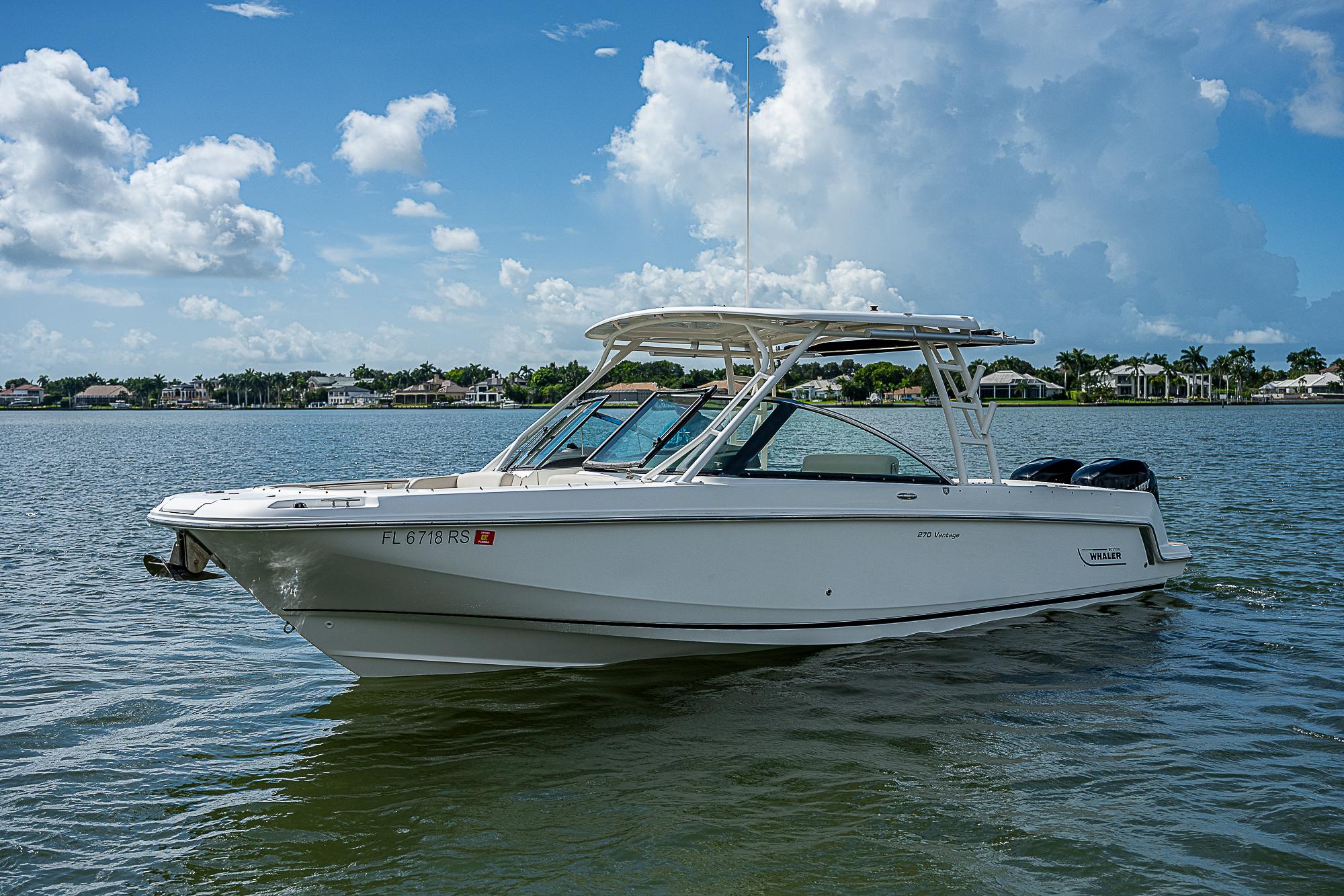 2018 Boston Whaler 270 Vantage boat on calm water under blue sky.