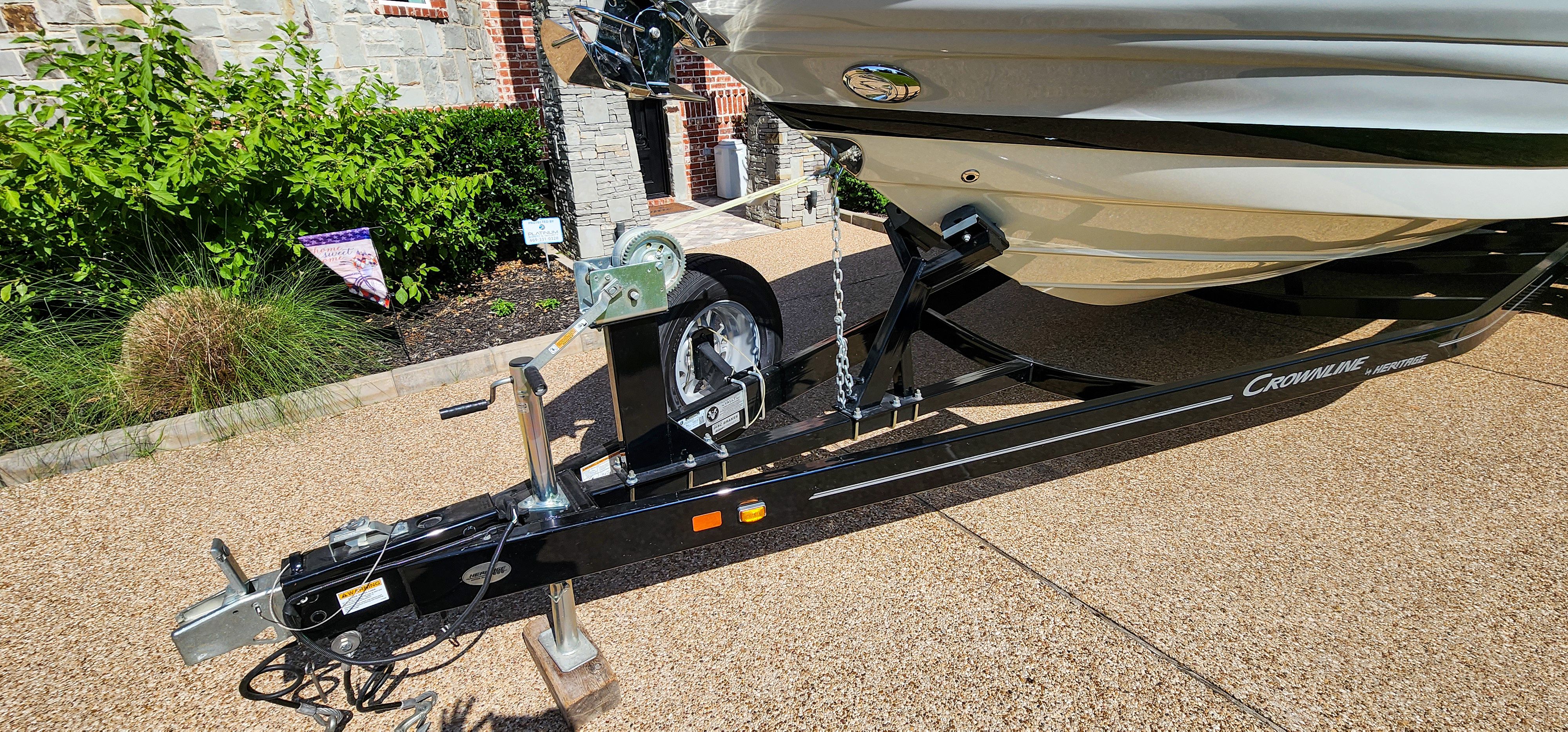 A 2017 Crownline 285SS boat on a trailer, parked on a paved area.