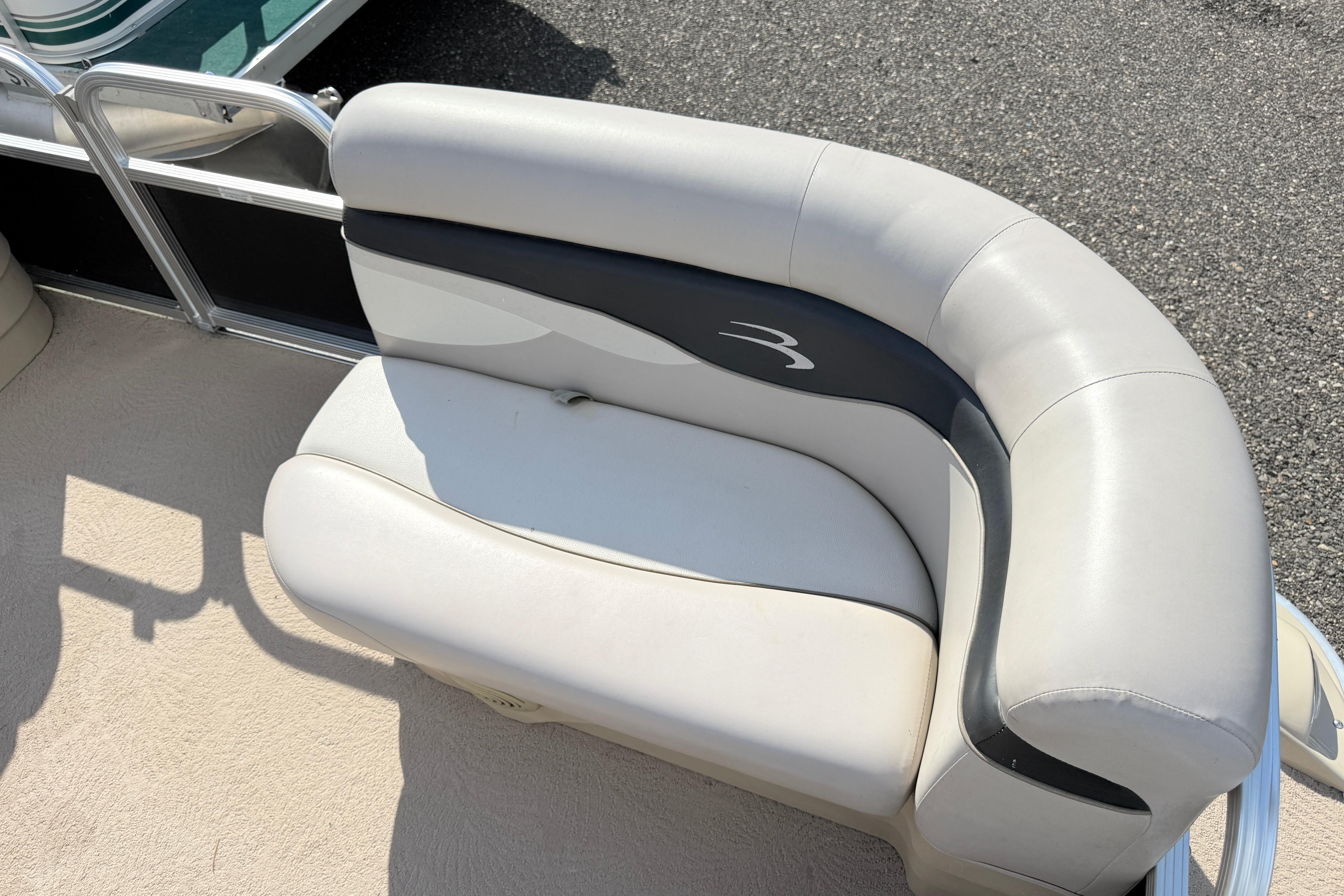 2010 Bennington 20SLi boat seat with white and black upholstery on a sunny day.