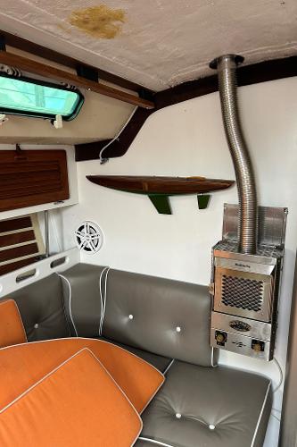 Interior of 1983 O'Day 39 sailboat with cozy seating and a compact heater.