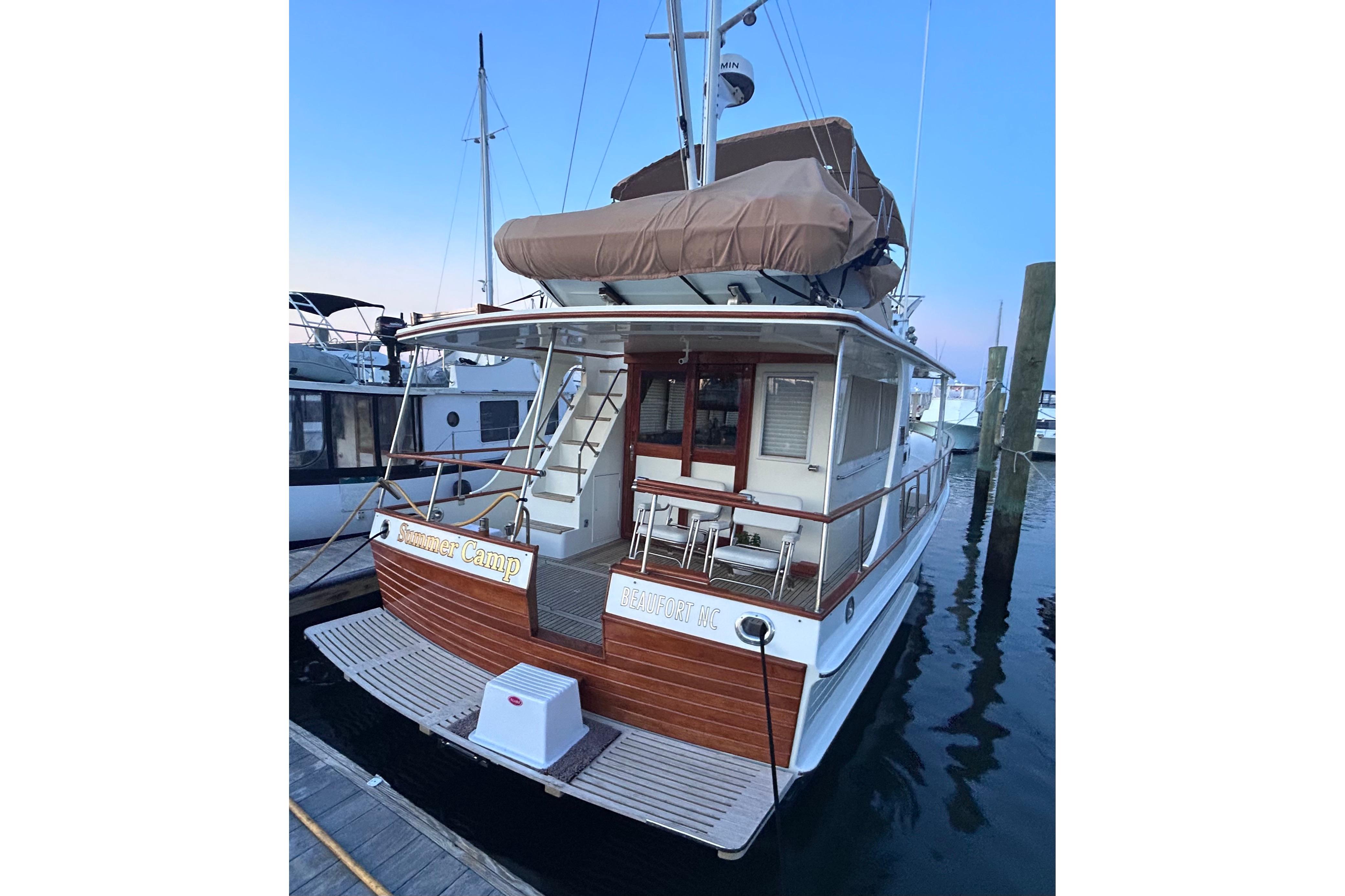 1999 Grand Banks 42 Europa yacht docked at marina, featuring classic wooden design.
