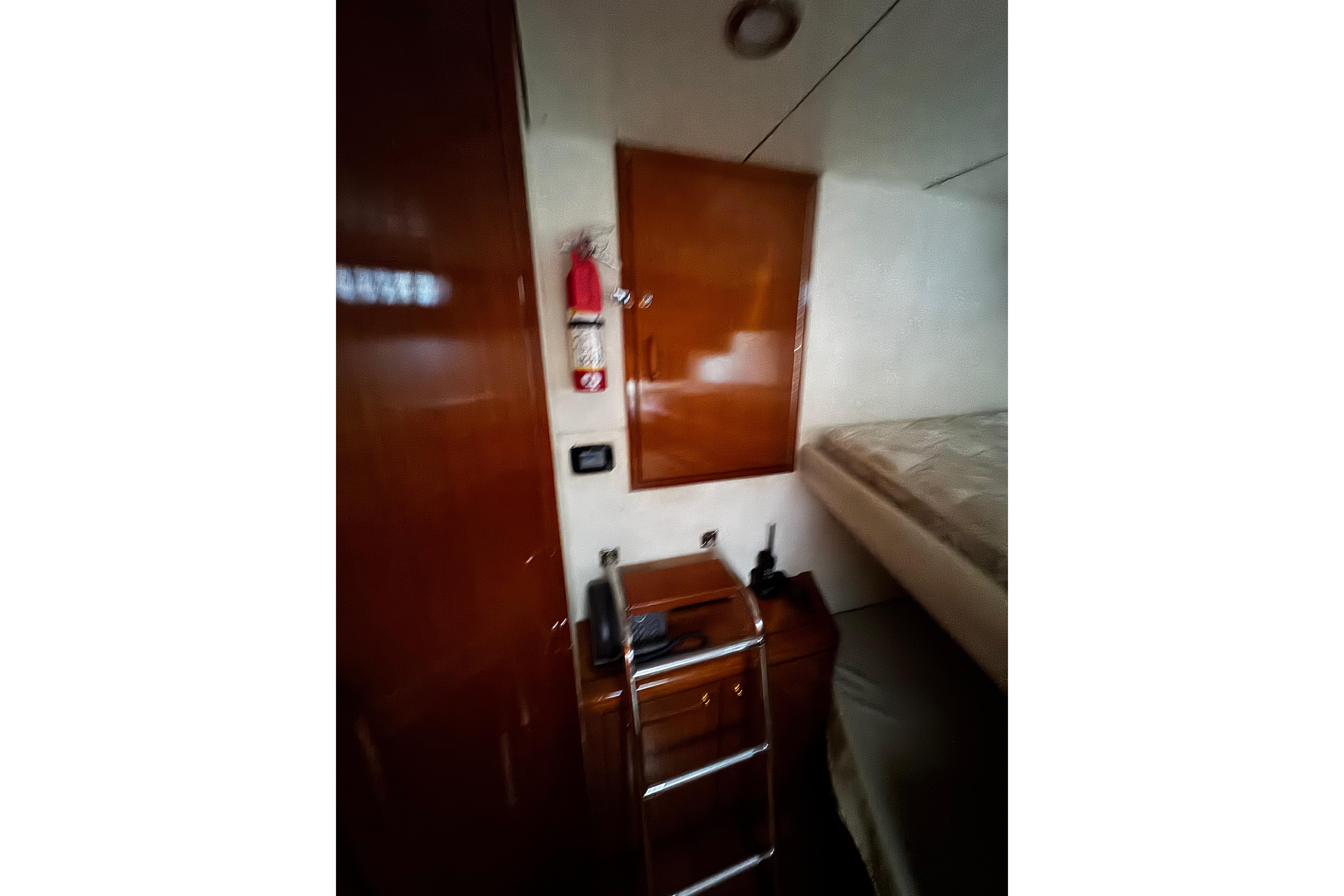 Interior of 1996 Hershine Benship 87 yacht with wooden cabinetry and a bed.