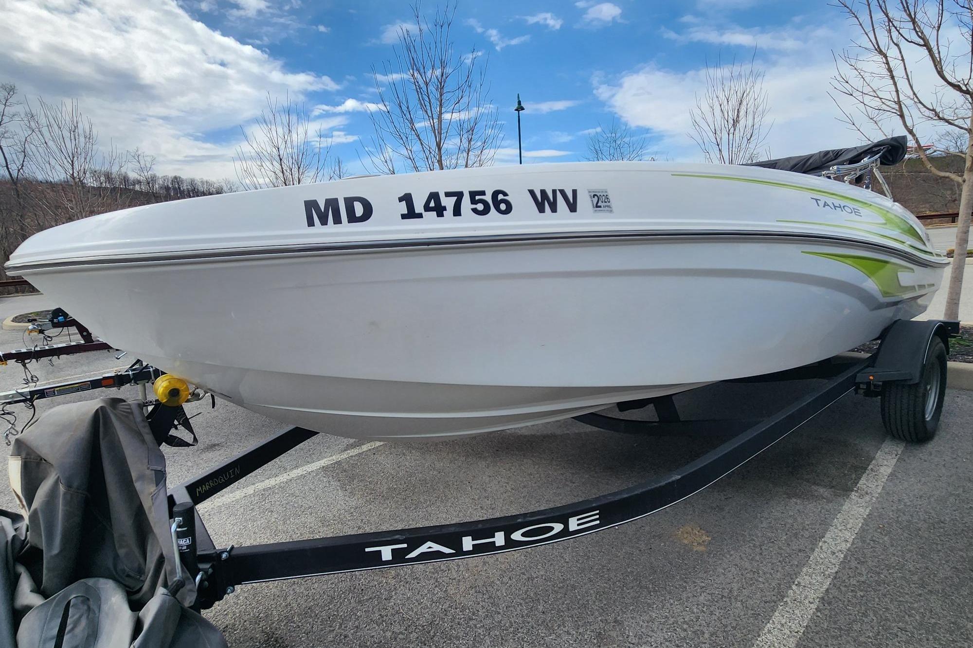 2023 Tahoe T18 boat on trailer, parked outdoors under a cloudy sky.