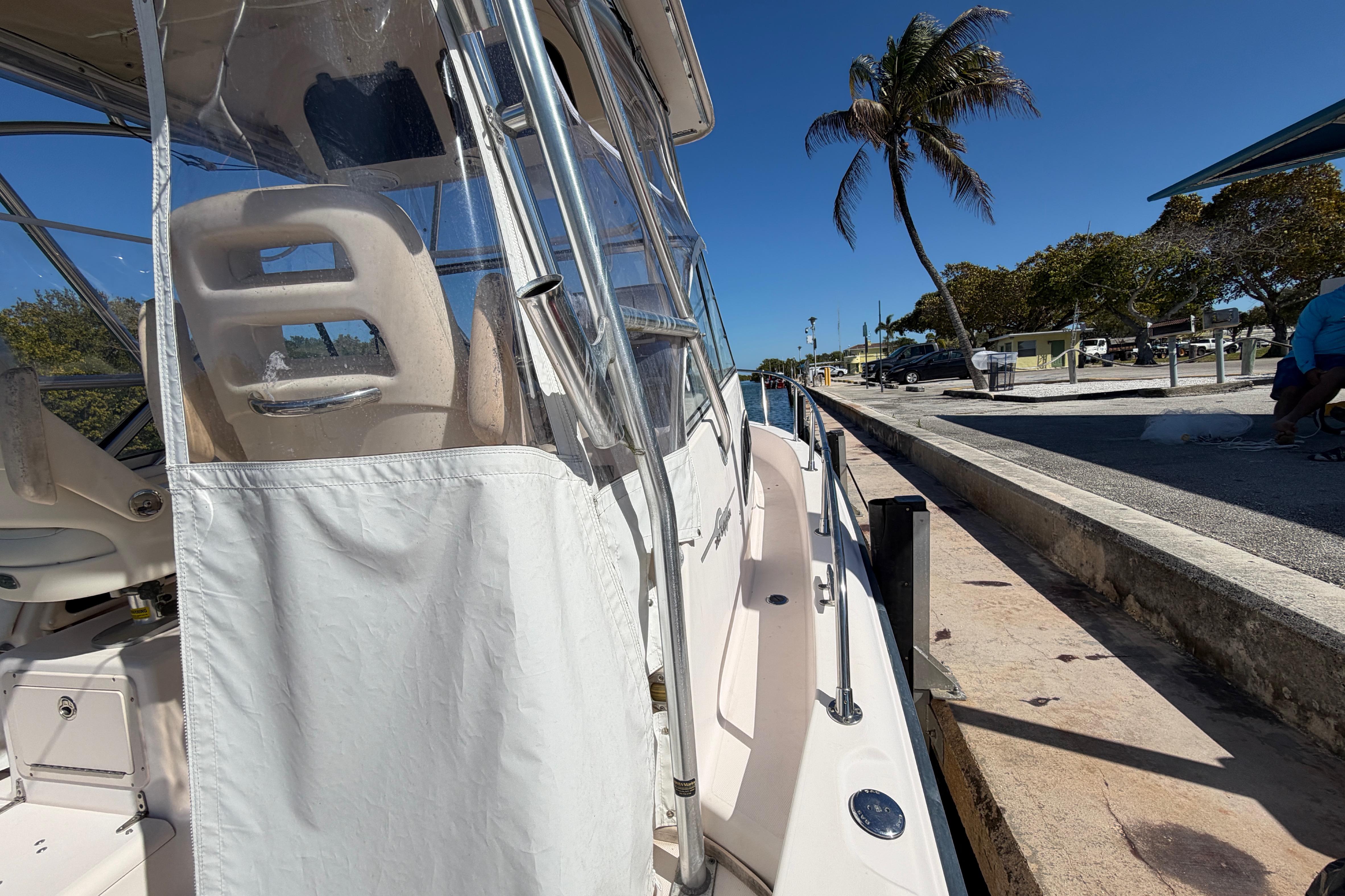 2006 Grady-White Sailfish 282 docked, featuring clear enclosure and coastal scenery.