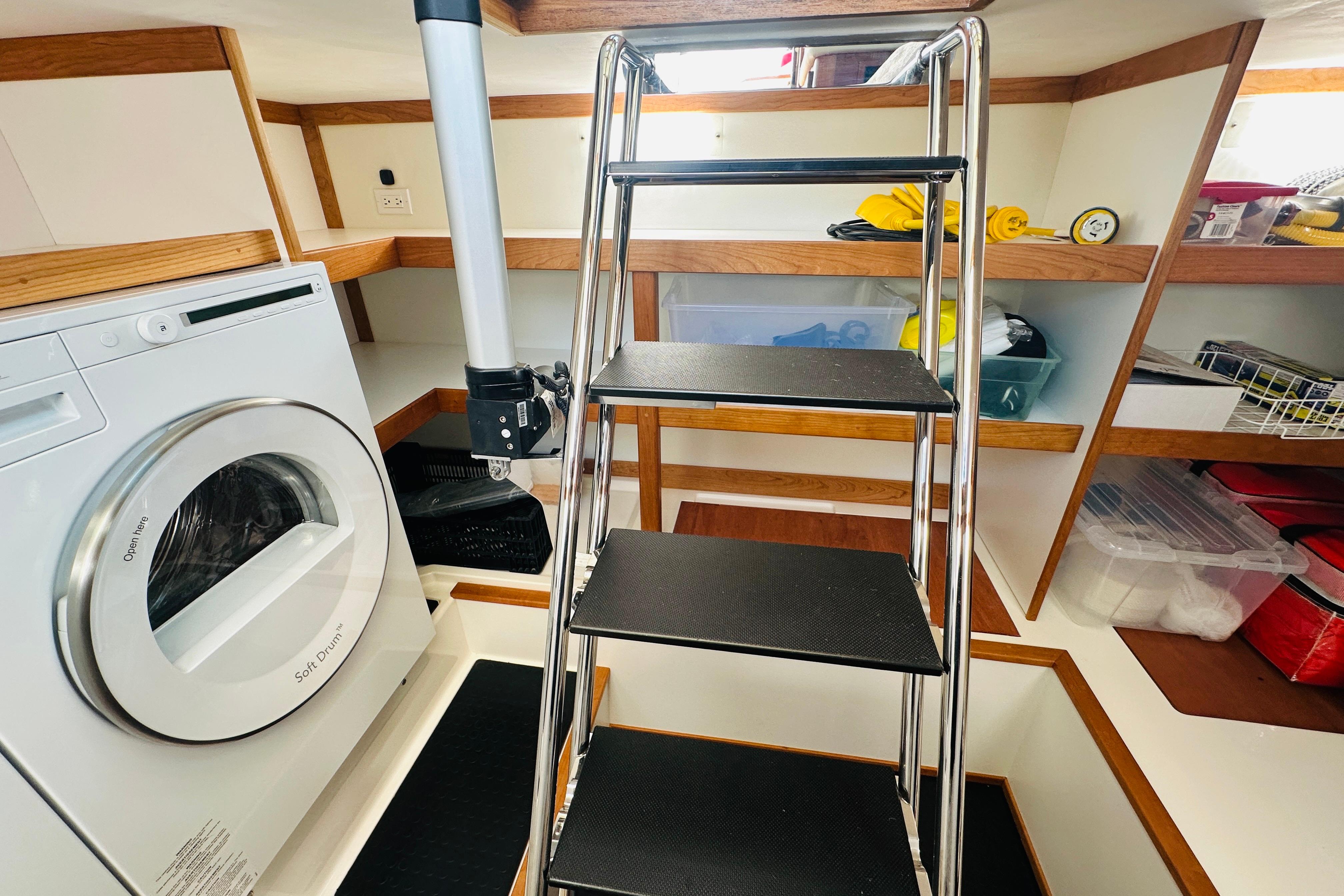 Laundry area with washer and storage shelves in 2025 Sabre 48 Salon Express yacht.