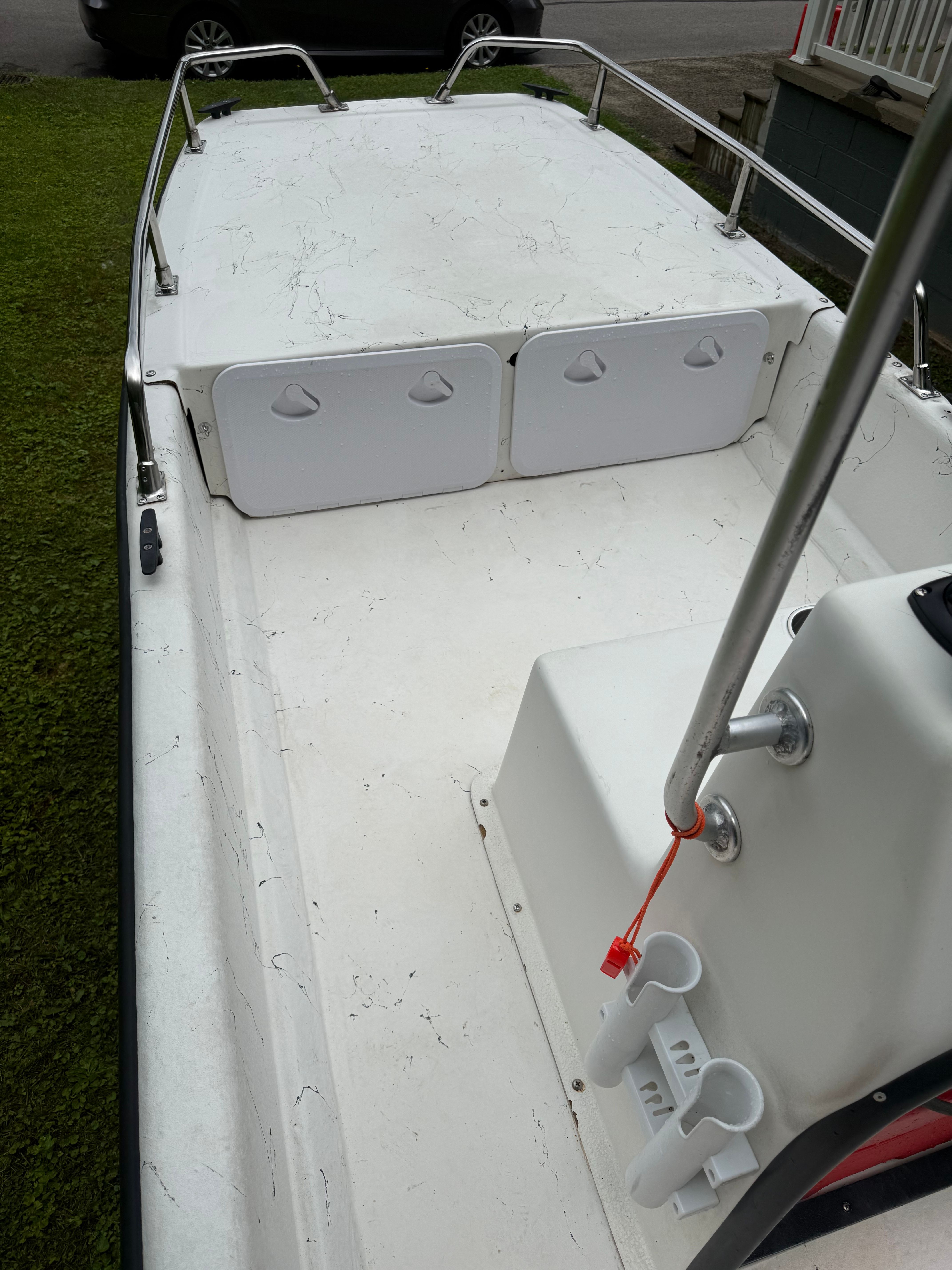 The image shows the deck of a 2009 Carolina Skiff J16CC boat with storage hatches.