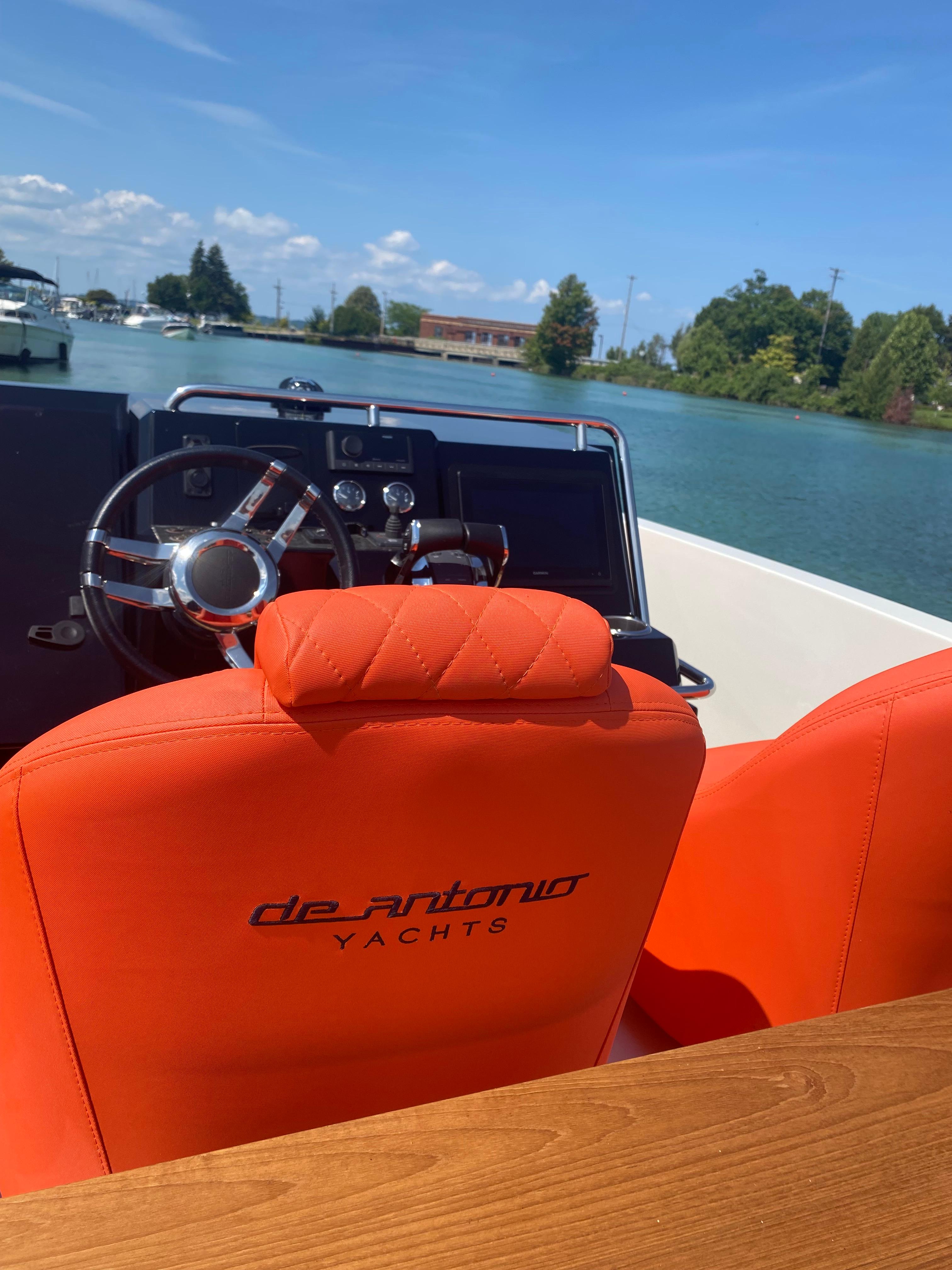 2020 De Antonio Yachts D 28 with orange seats and steering wheel on a sunny day.