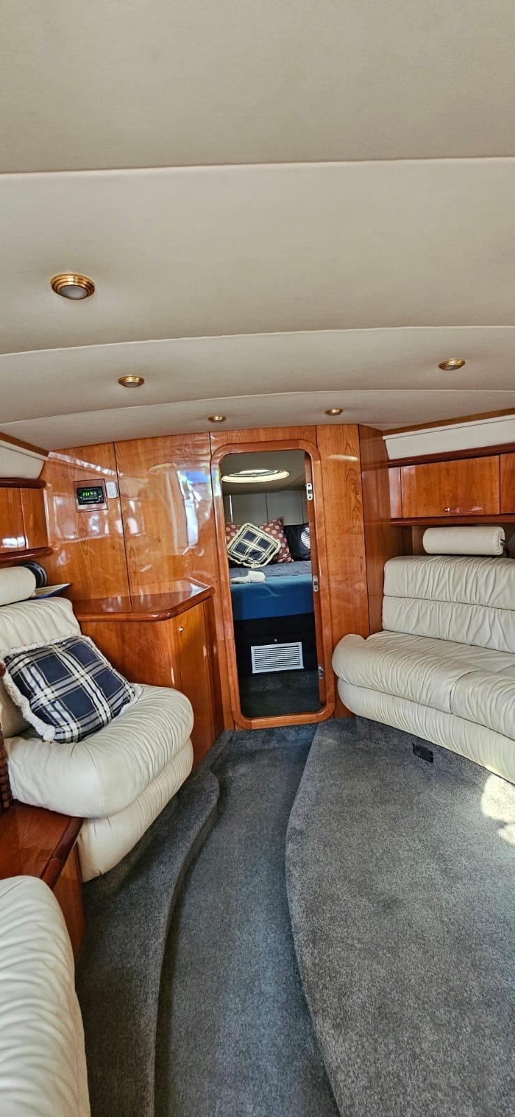 Interior of 2001 Sunseeker Superhawk 50 yacht with plush seating and wood paneling.