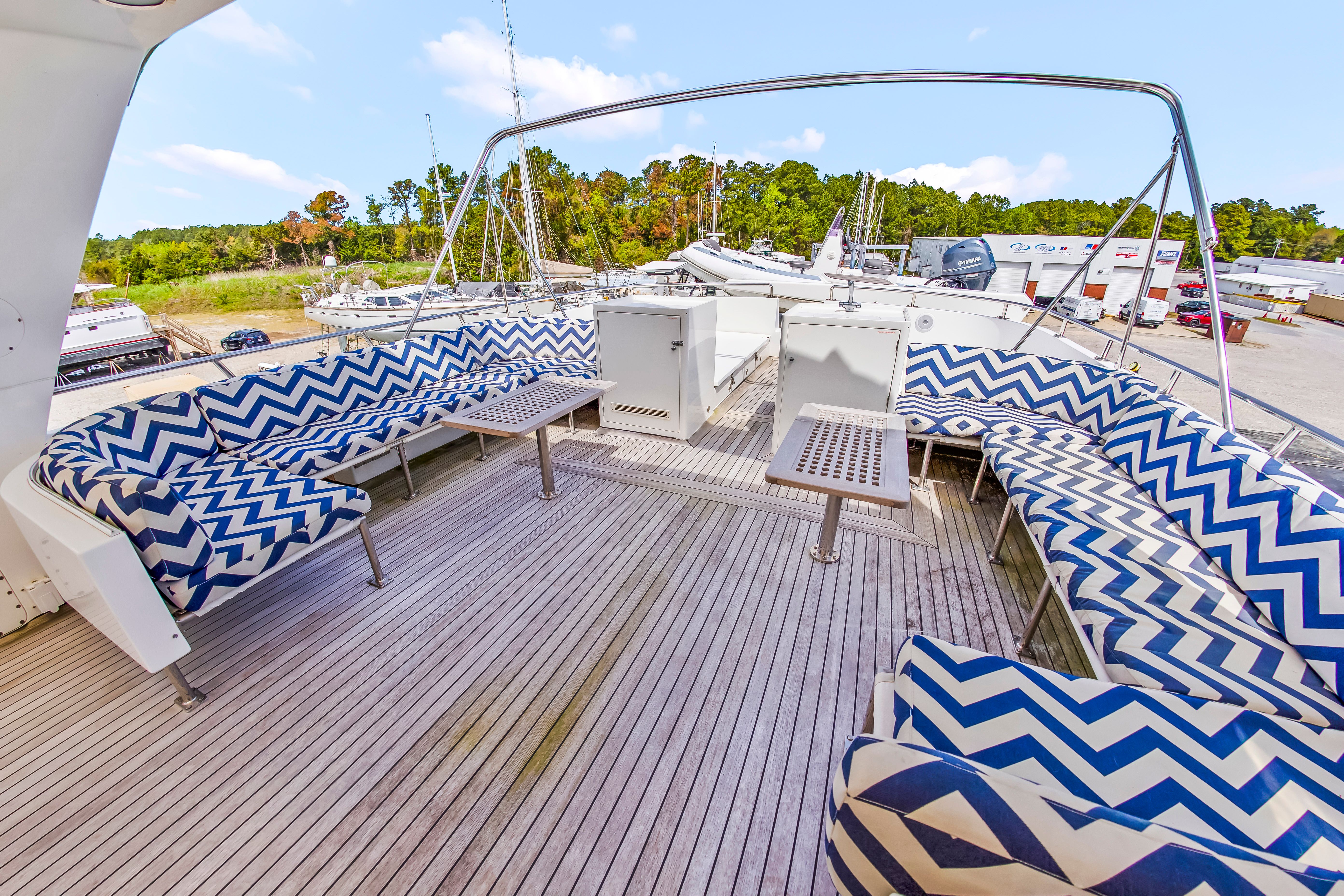 The image shows the deck of a 1987 Jongert 78 Motor Yacht with patterned seat cushions.
