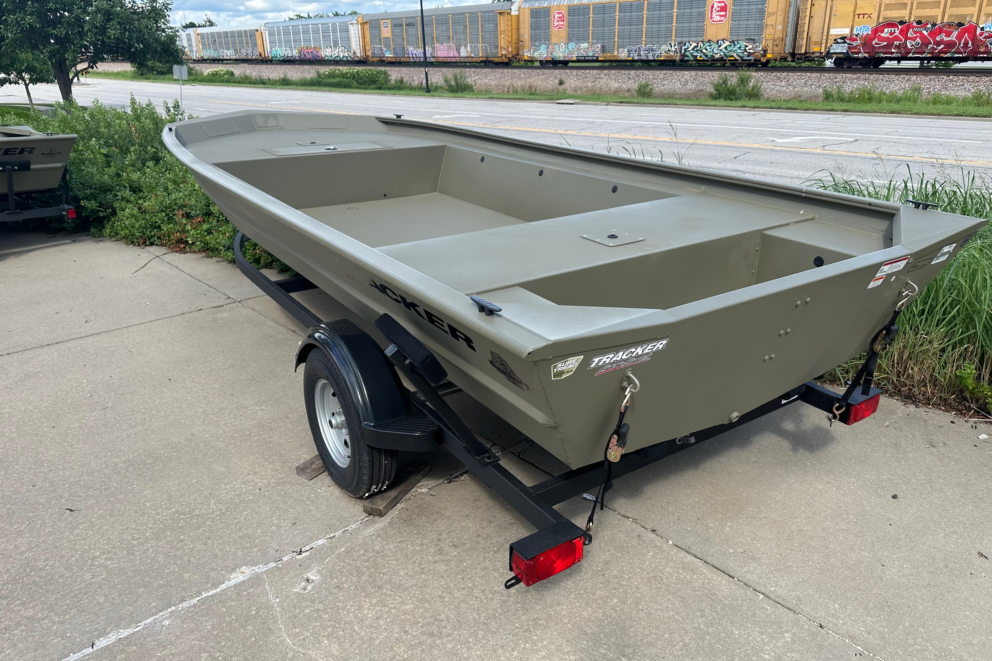 2026 Tracker Grizzly 1754 Utility boat on trailer, parked near train tracks.