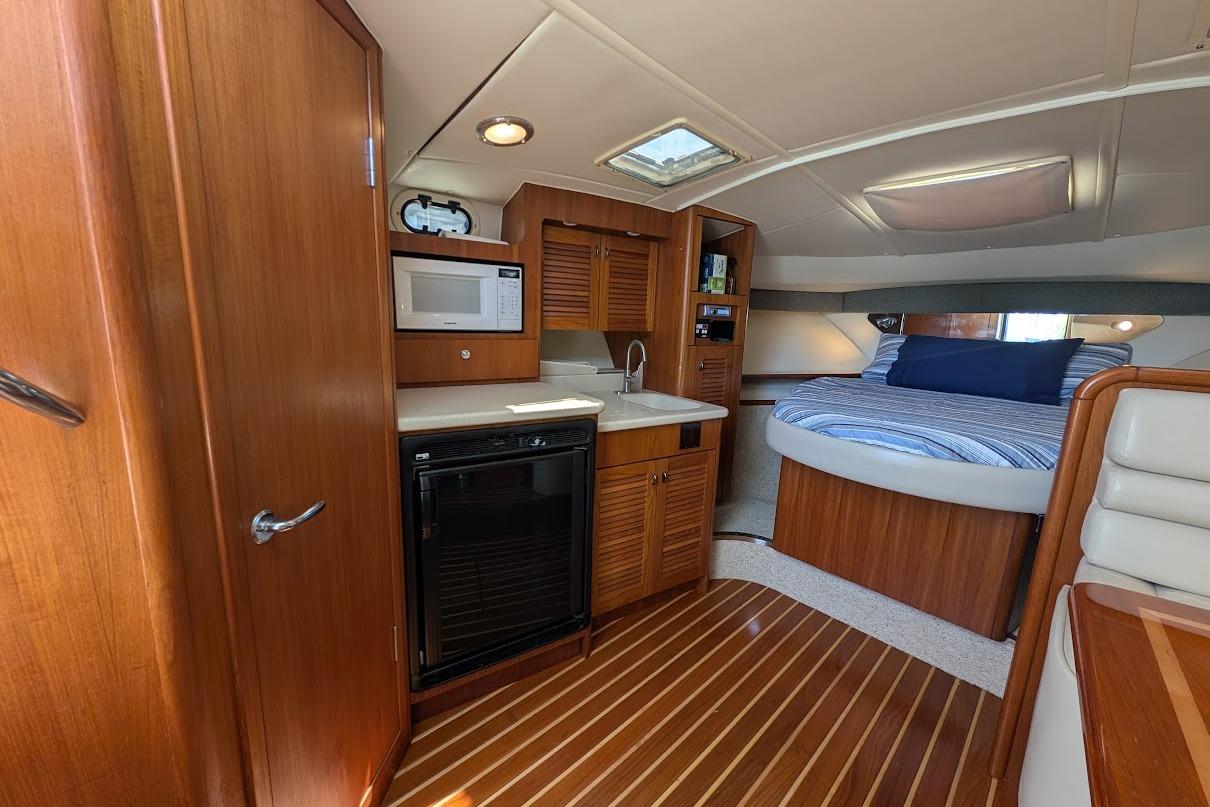 Interior of 2000 Pursuit 3400 Express yacht with kitchenette and cozy sleeping area.