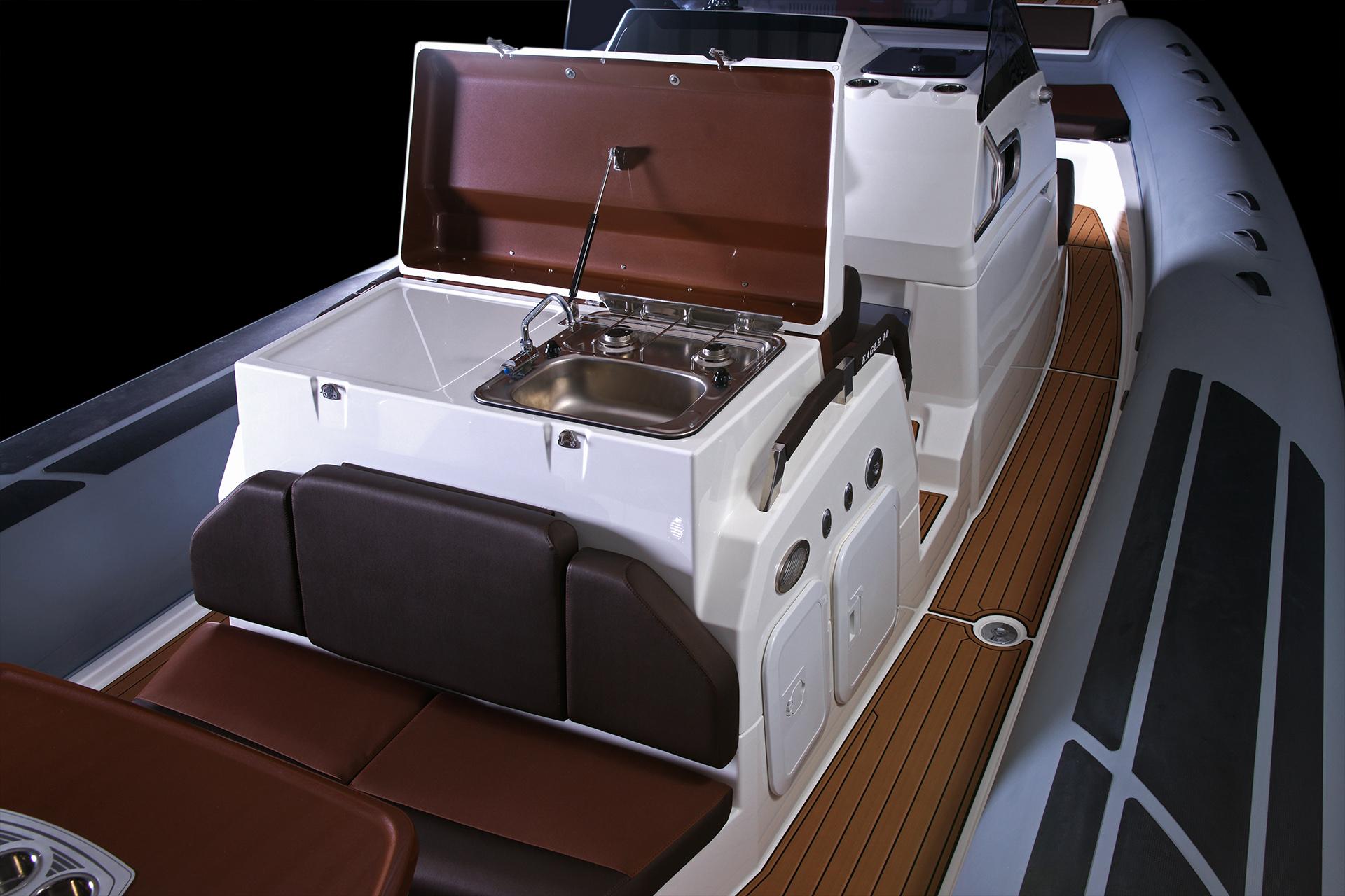 2025 Brig Eagle 10 boat interior with seating and kitchenette, featuring a sink and stove.