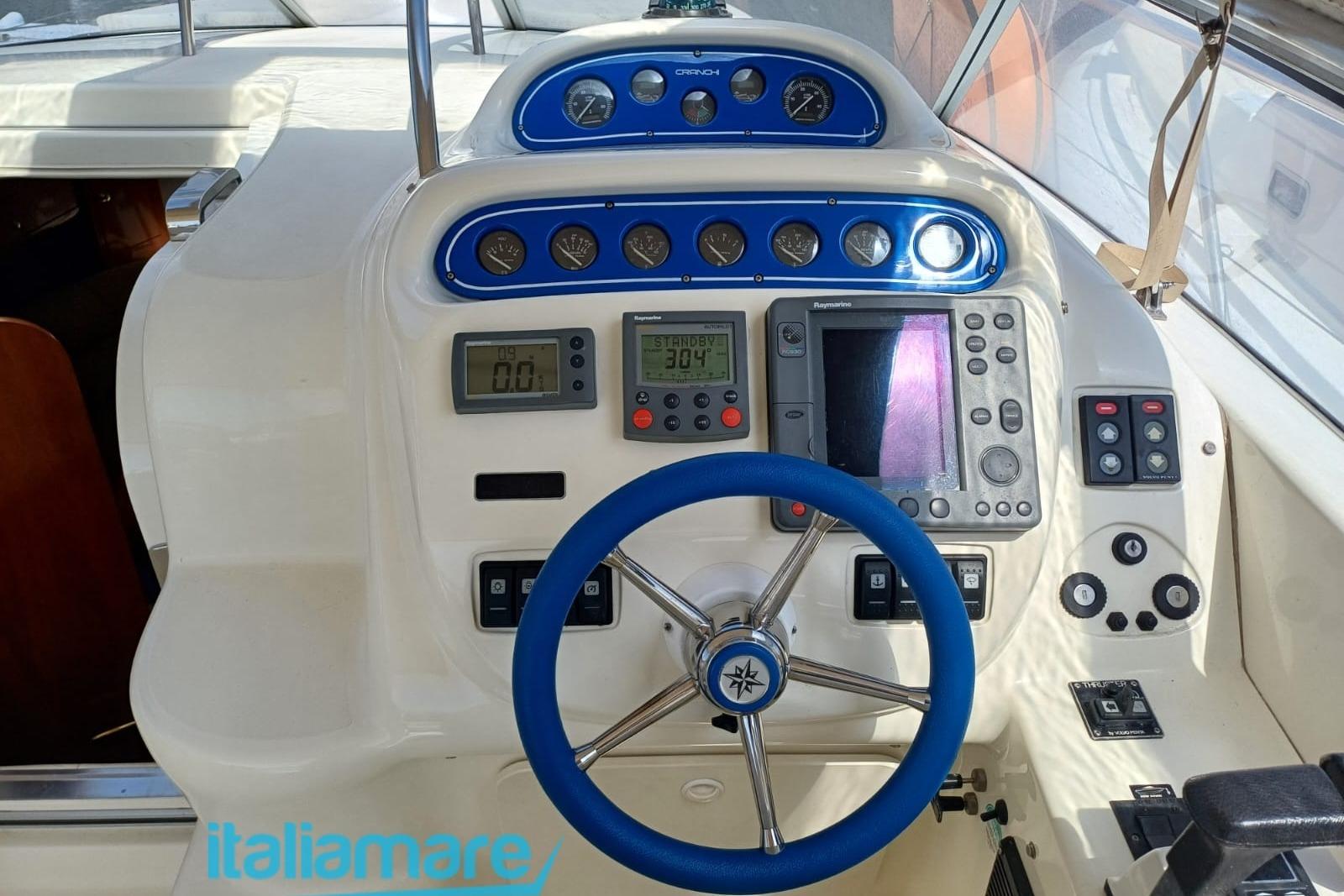 Control panel of 2006 Cranchi Zaffiro 34 boat with blue steering wheel and navigation instruments.