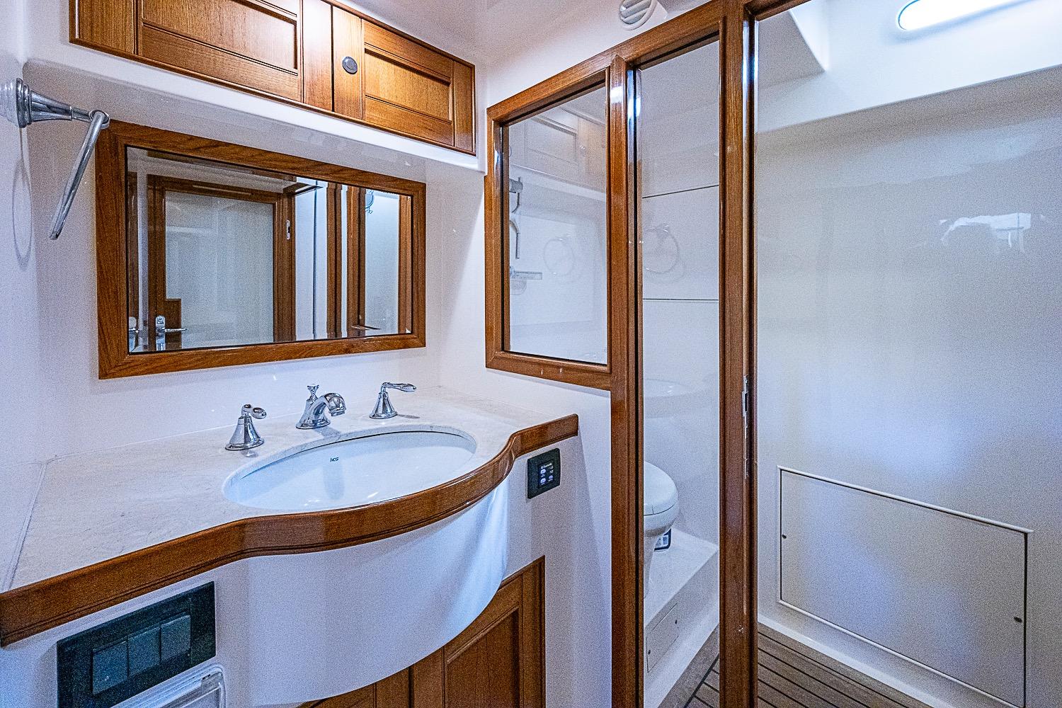Luxurious bathroom in 2014 Marlow 80 Explorer yacht with wooden accents and modern fixtures.