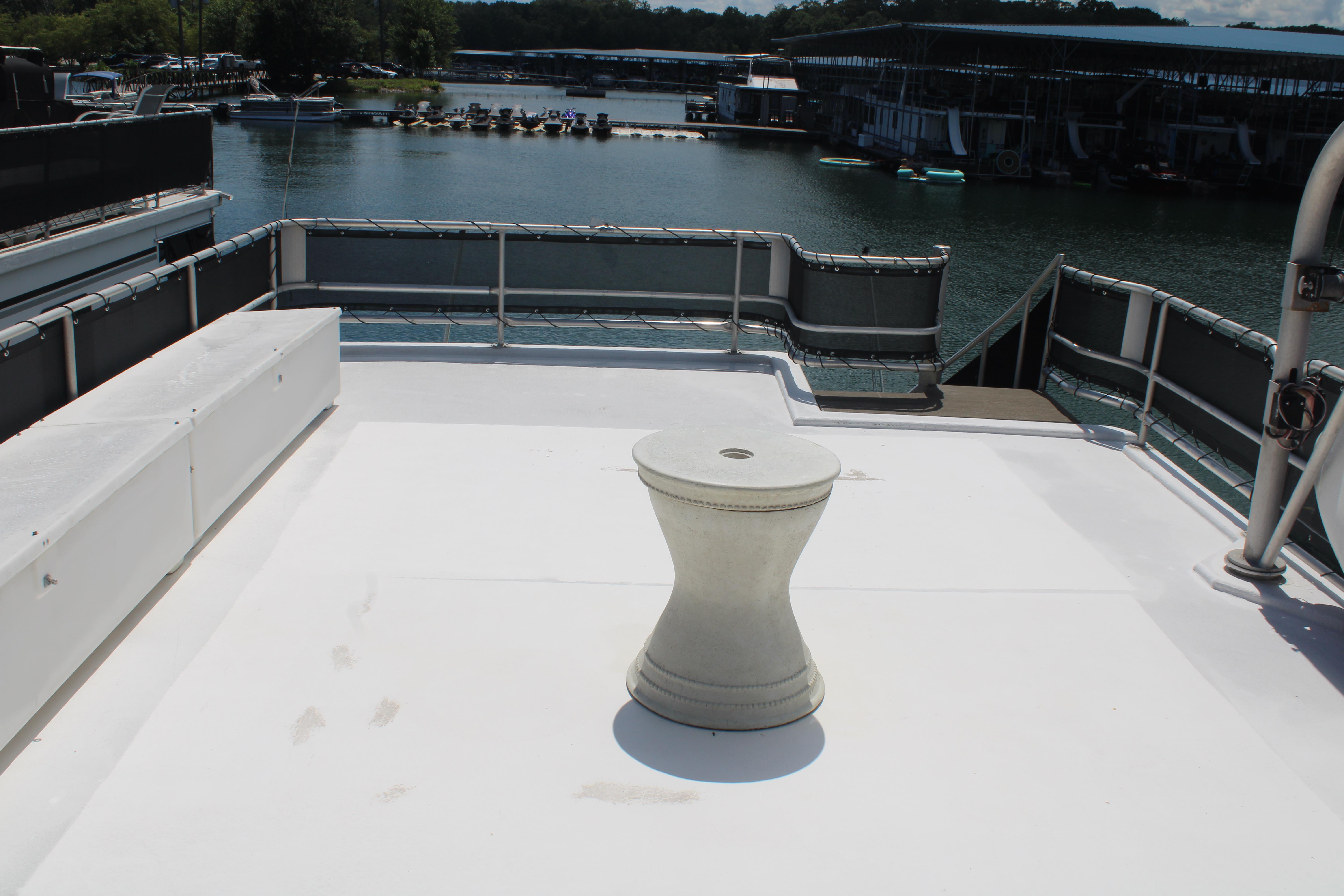 Rooftop deck of 1992 Sumerset 66 houseboat with seating and table, overlooking marina.