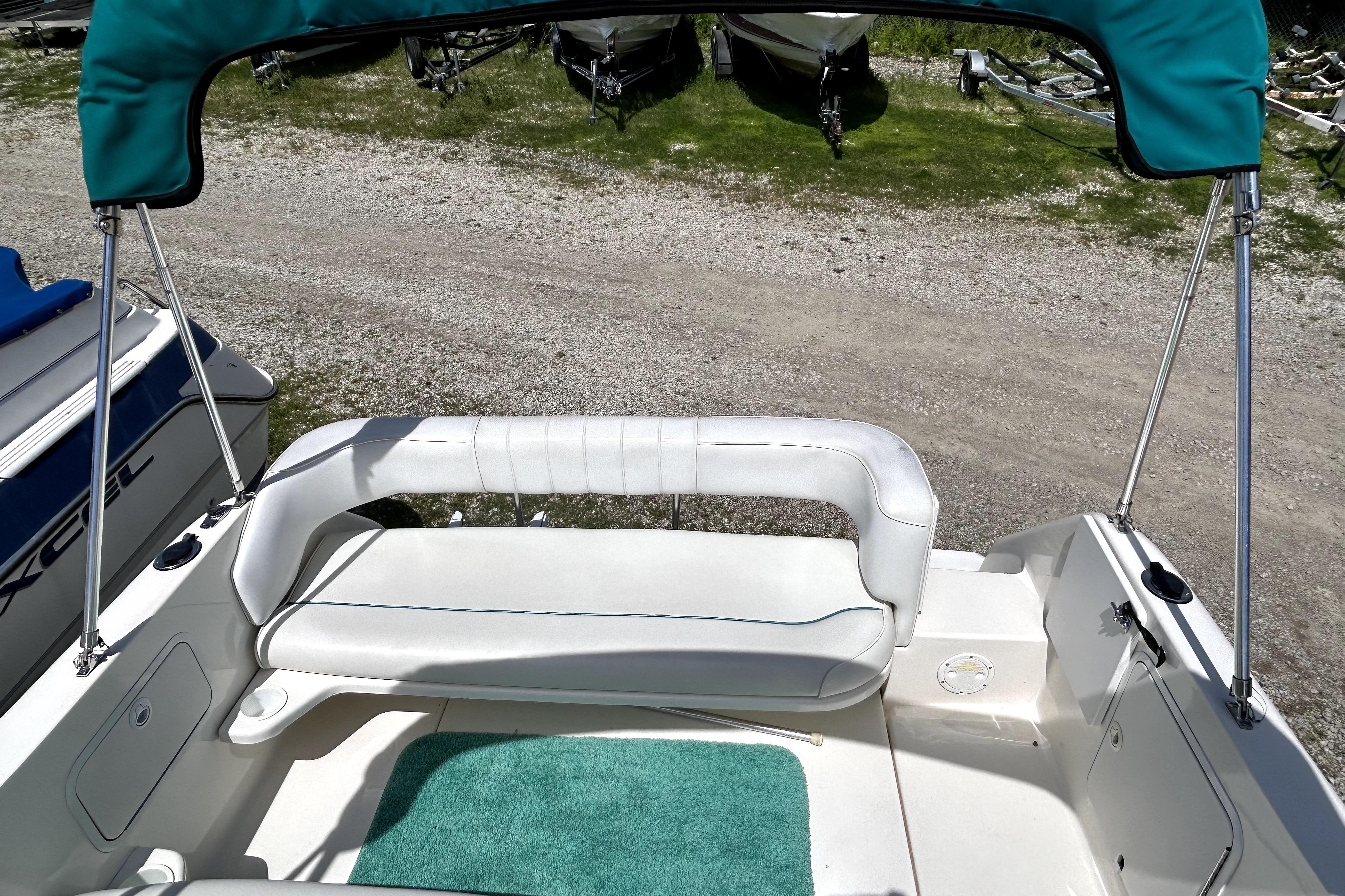 1995 Sea Ray 250 Sundancer boat interior with white seating and teal canopy.