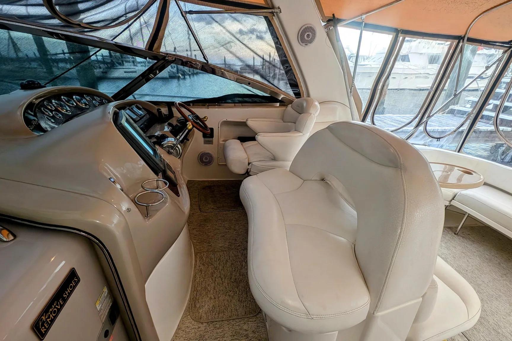 Interior of 2000 Sea Ray 380 Sundancer yacht with plush seating and helm controls.