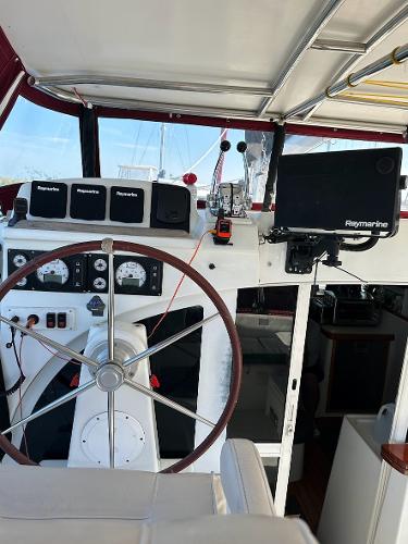 Interior view of a 2004 Lagoon 380 catamaran cockpit with navigation equipment and steering wheel.