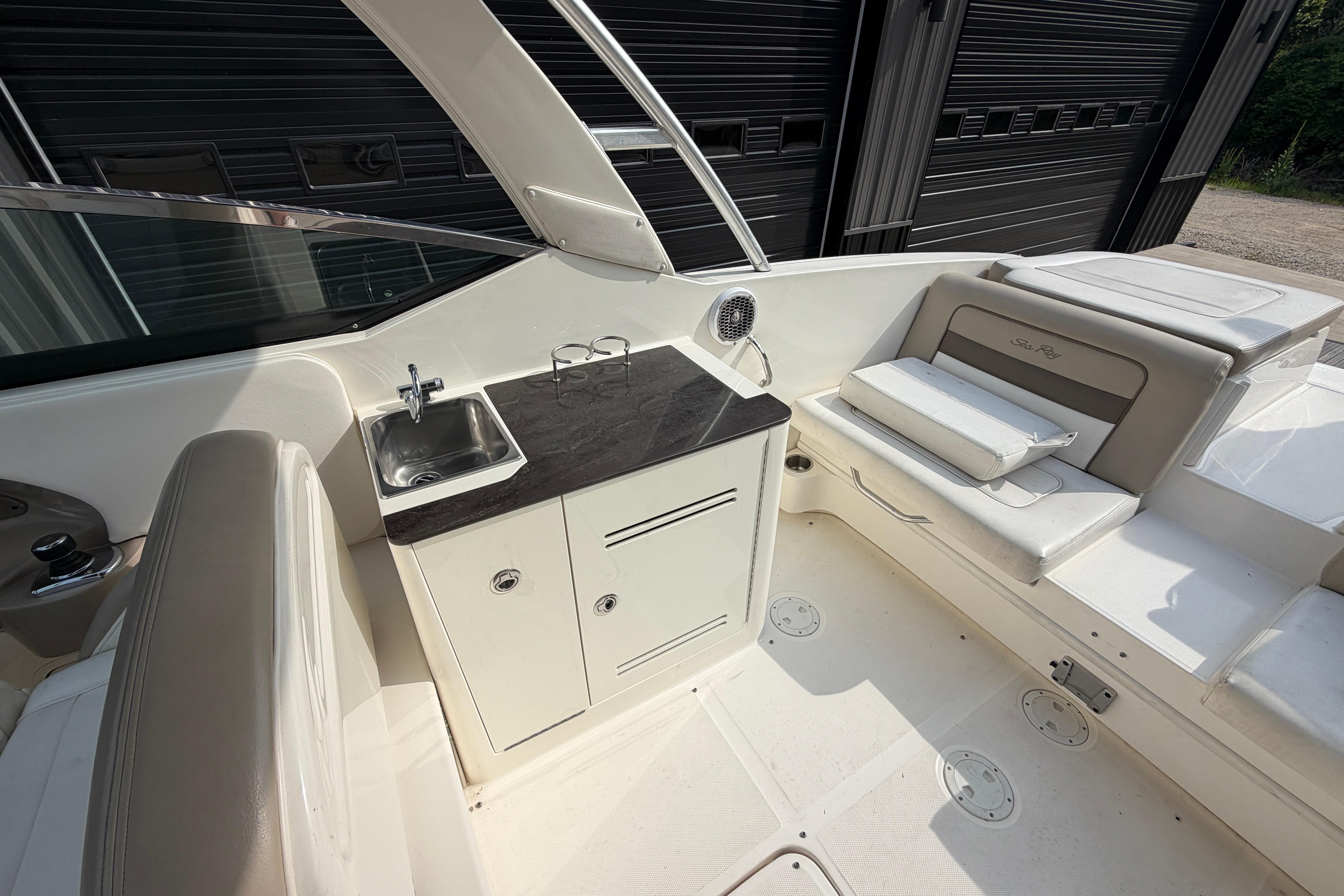 Interior of a 2013 Sea Ray 300 SLX boat with seating and a small sink area.
