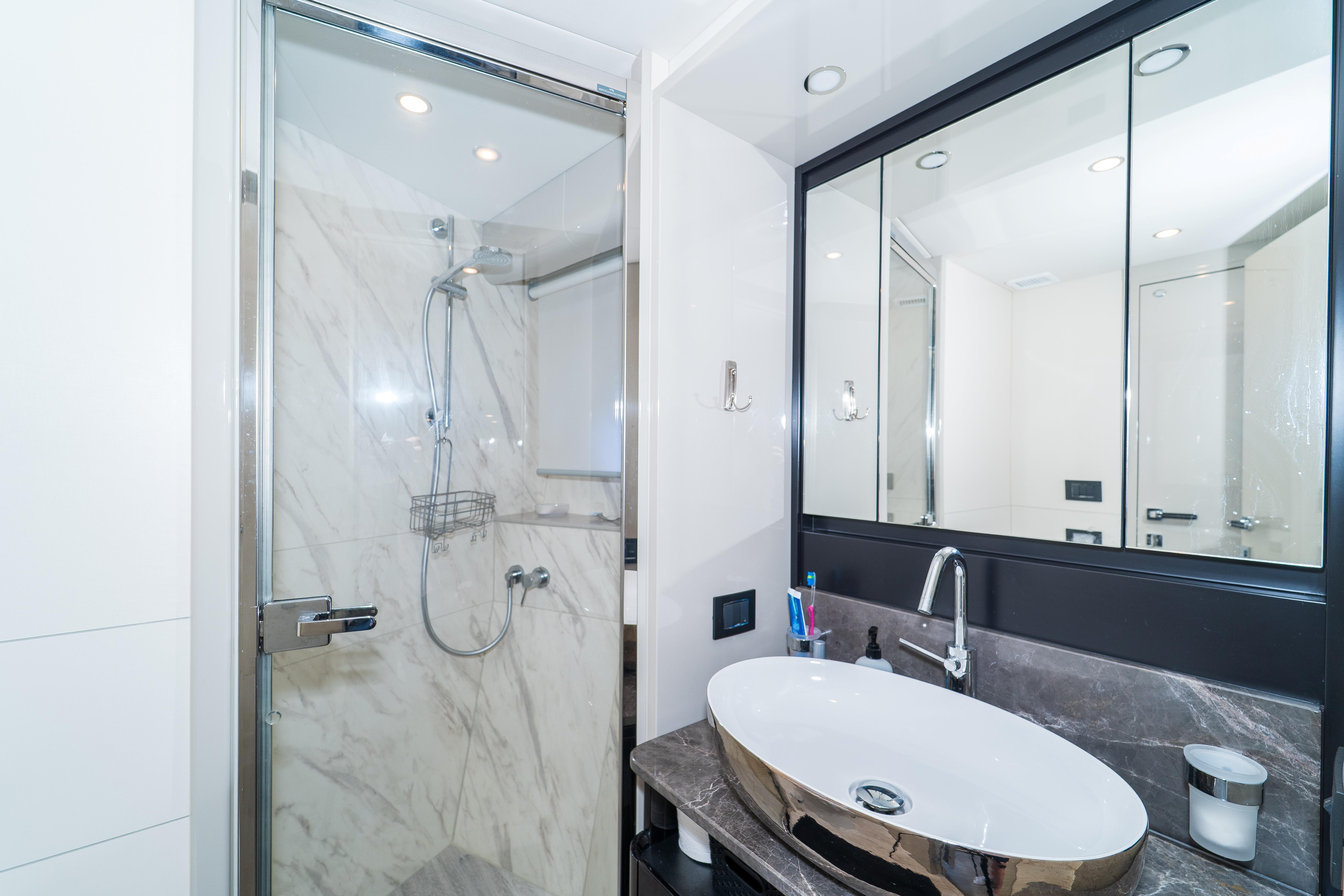 Luxurious bathroom on 2023 Absolute 62 Fly yacht with modern shower and elegant sink.