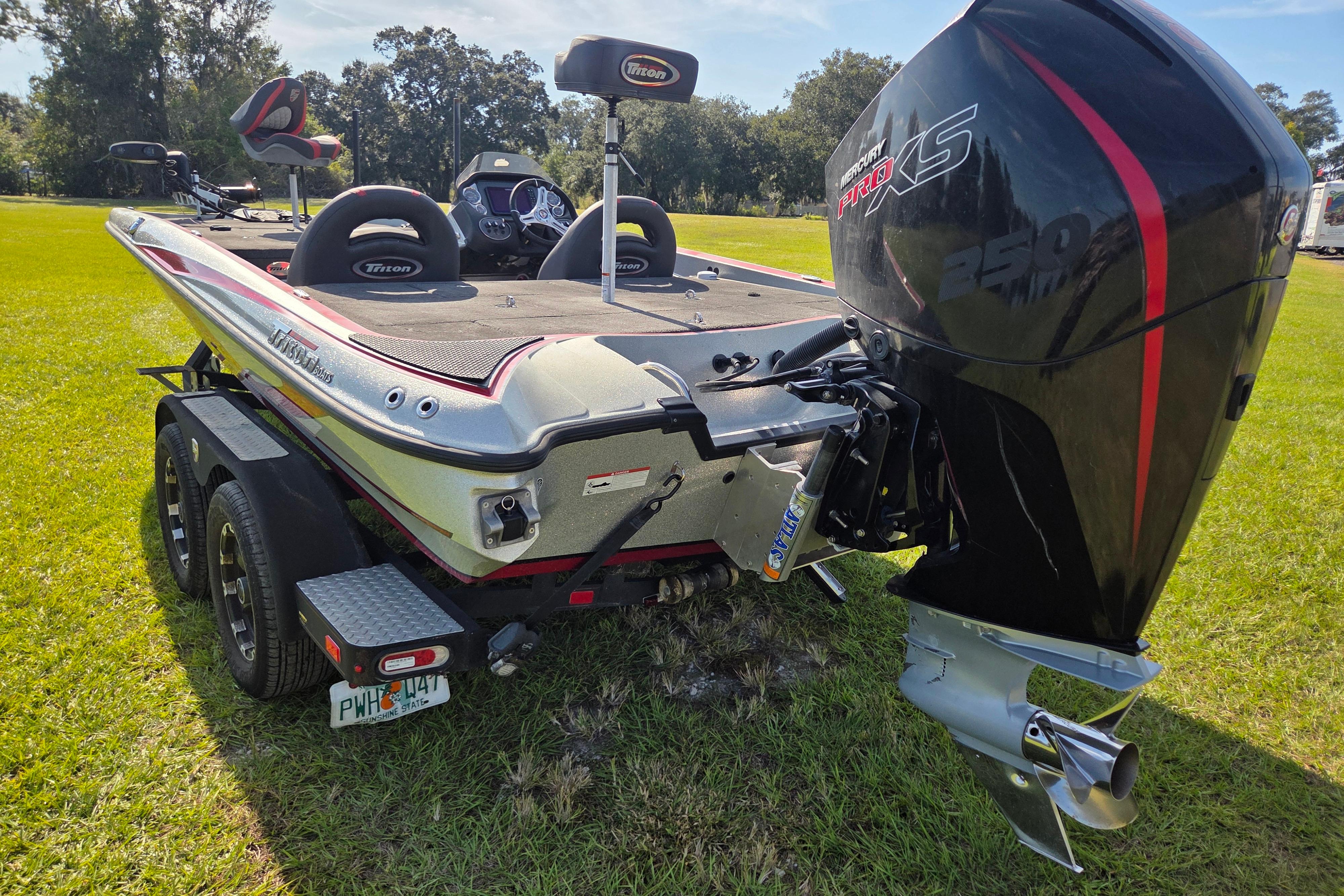 2021 Triton 20 TrX boat with Mercury Pro XS 250 engine on grassy field.