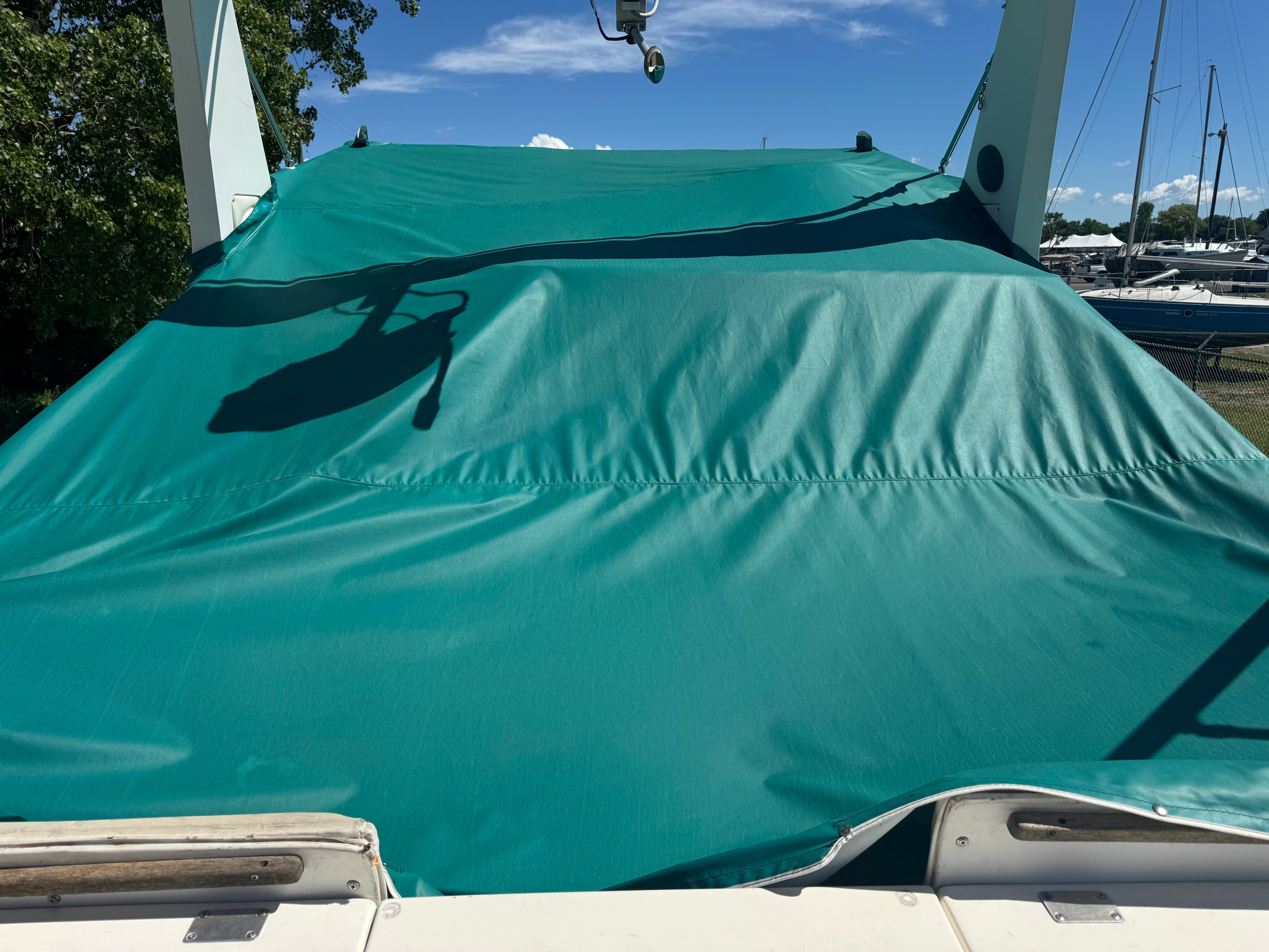 A green cover shades the cockpit of a 1992 Cruisers Yachts Esprit 3370.